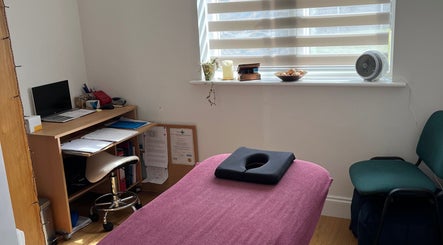 JH Sport Manual Therapy cozy room in Norwich, England, GB with a treatment table, desk, and natural light.