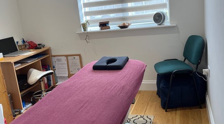 Comfortable therapy room at JH Sport Manual Therapy, Norwich, England, GB with massage table and desk.