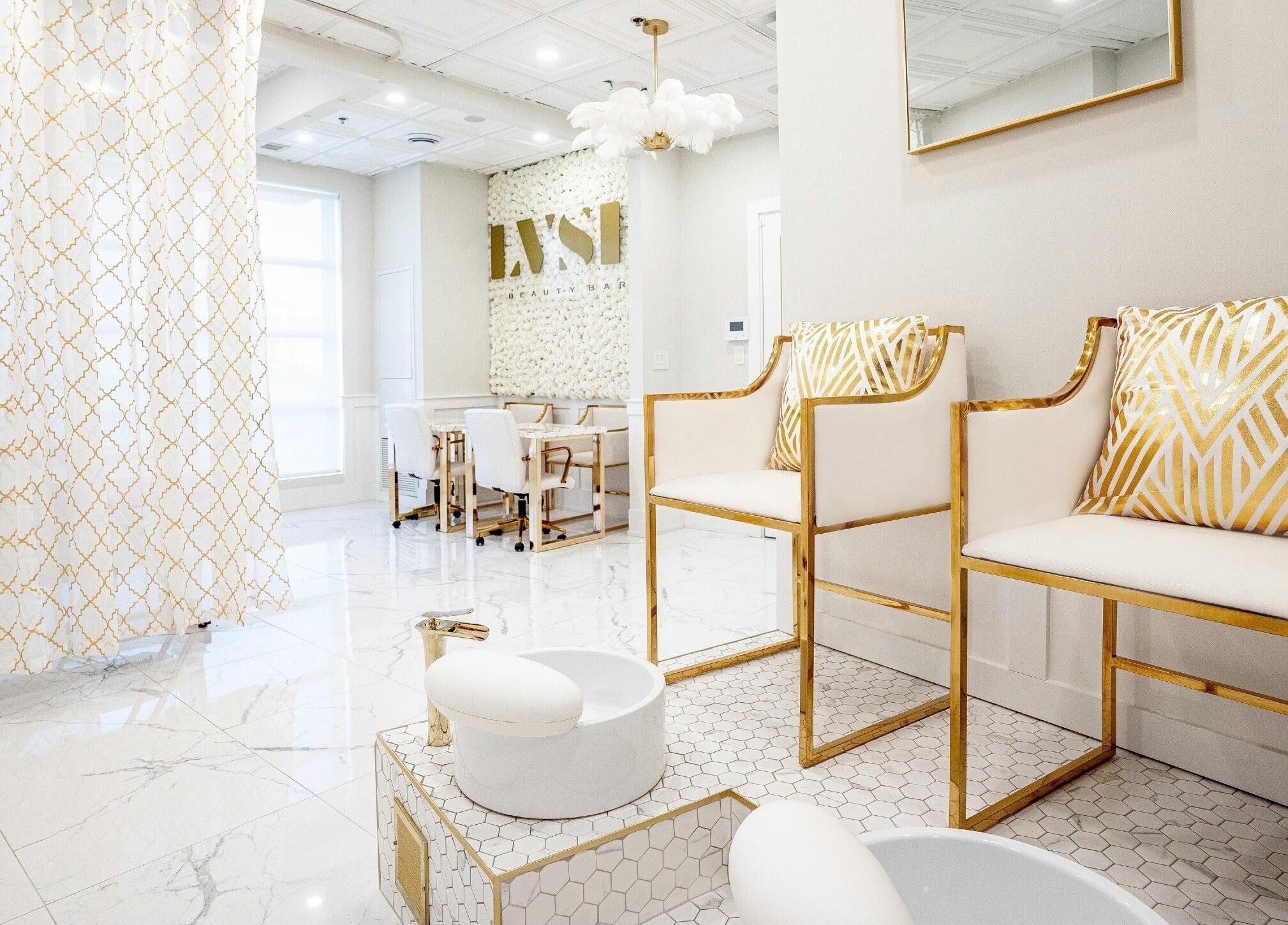 Luxurious interior of LVSH Beauty Bar in Vaughan, Ontario, CA with chic white and gold seating and decor.