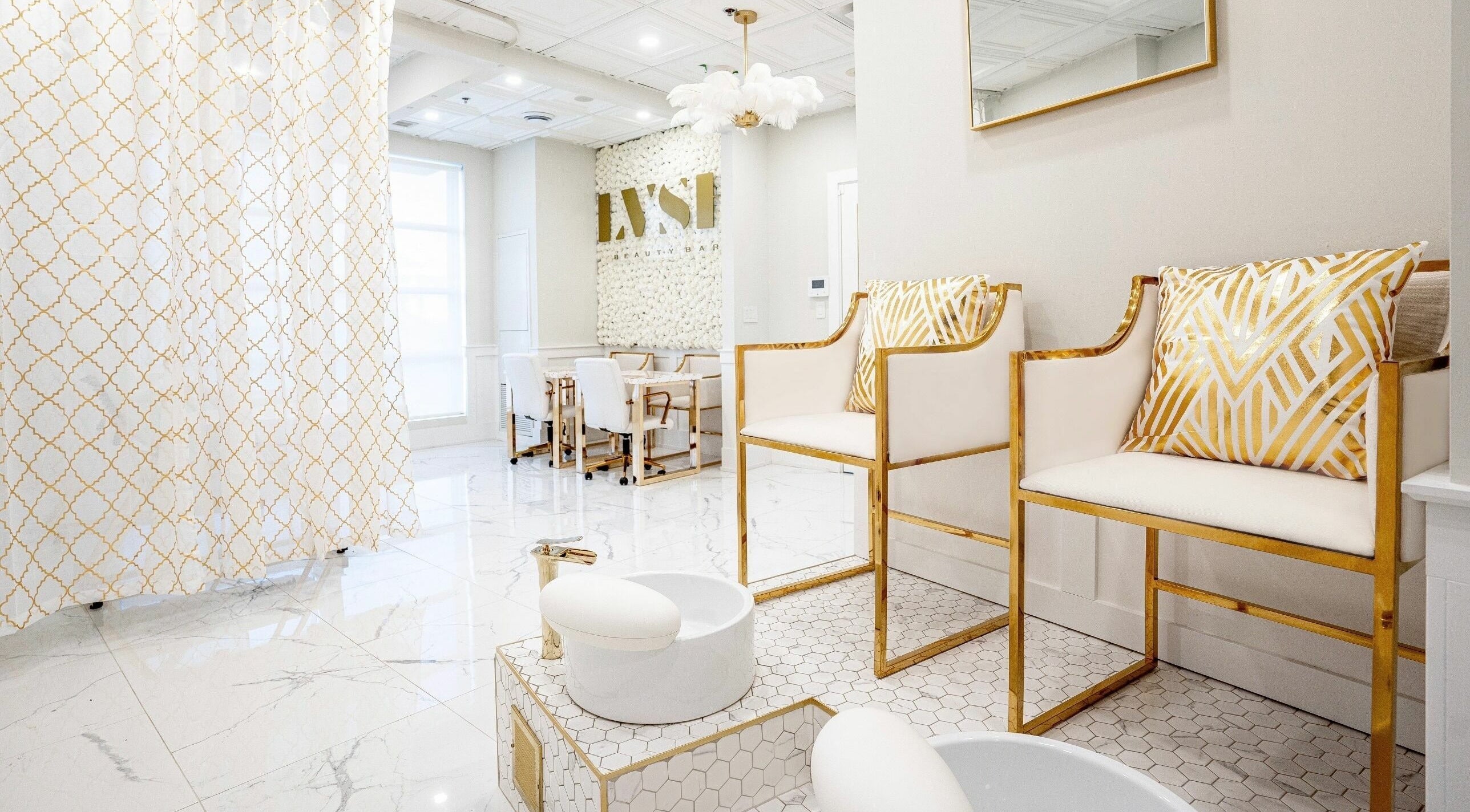 Luxurious interior of LVSH Beauty Bar in Vaughan, Ontario, CA with chic white and gold seating and decor.