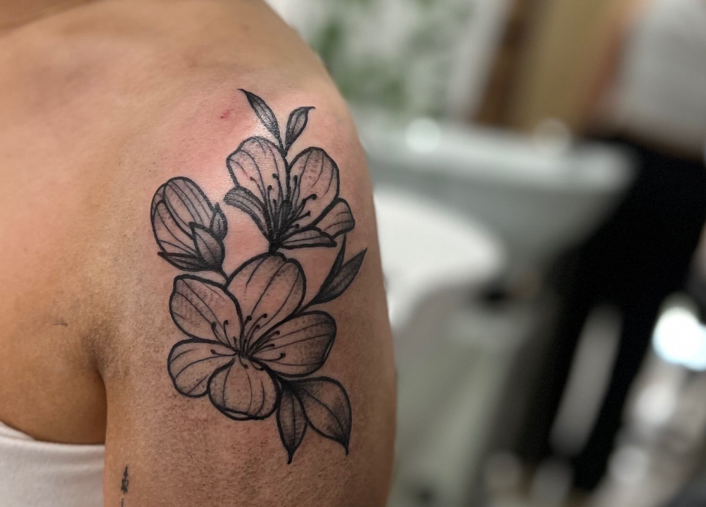 Floral tattoo on arm at All Dolled Up - Leeds, Kippax, England, GB. Elegant artistry captured.