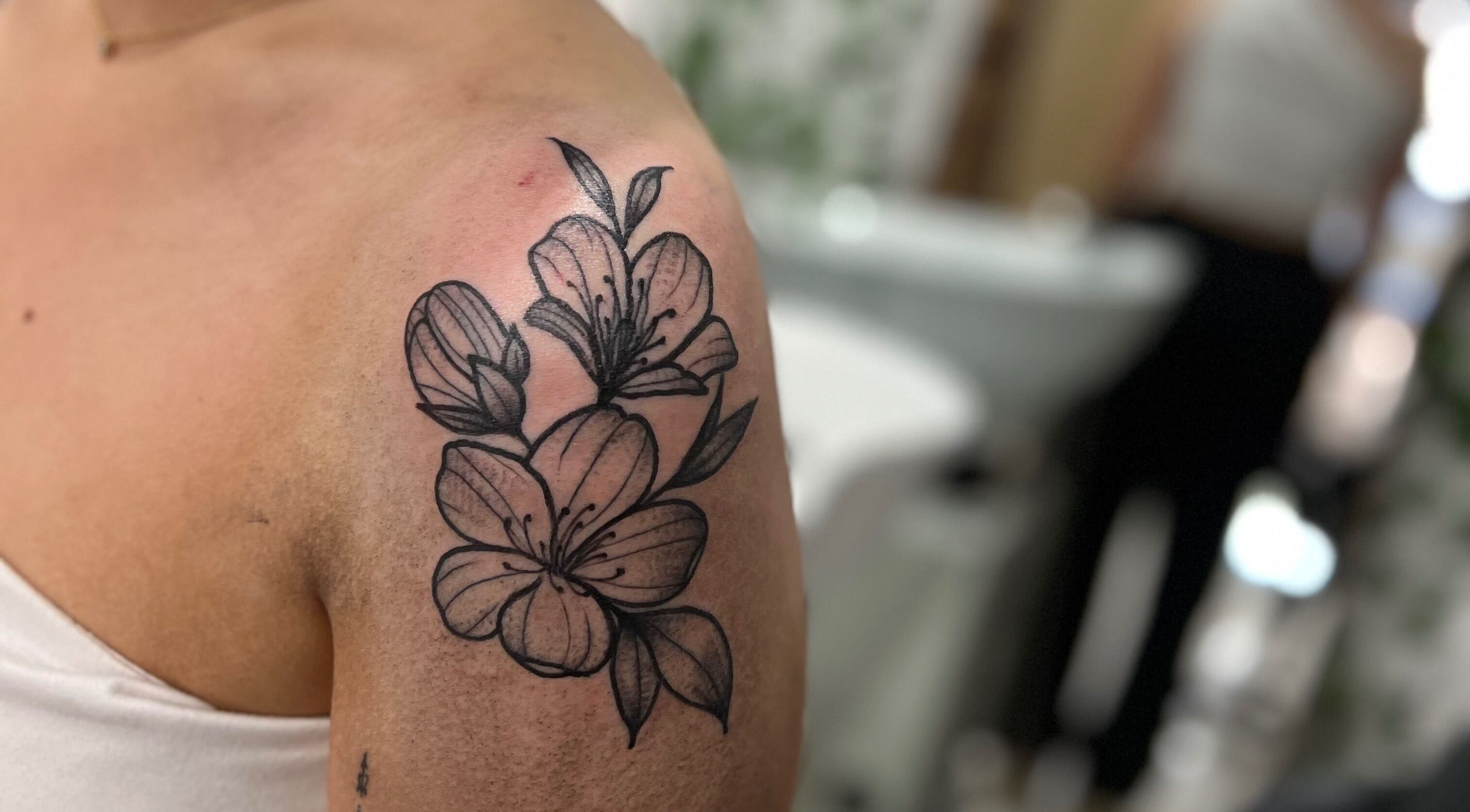 Floral tattoo on arm at All Dolled Up - Leeds, Kippax, England, GB. Elegant artistry captured.