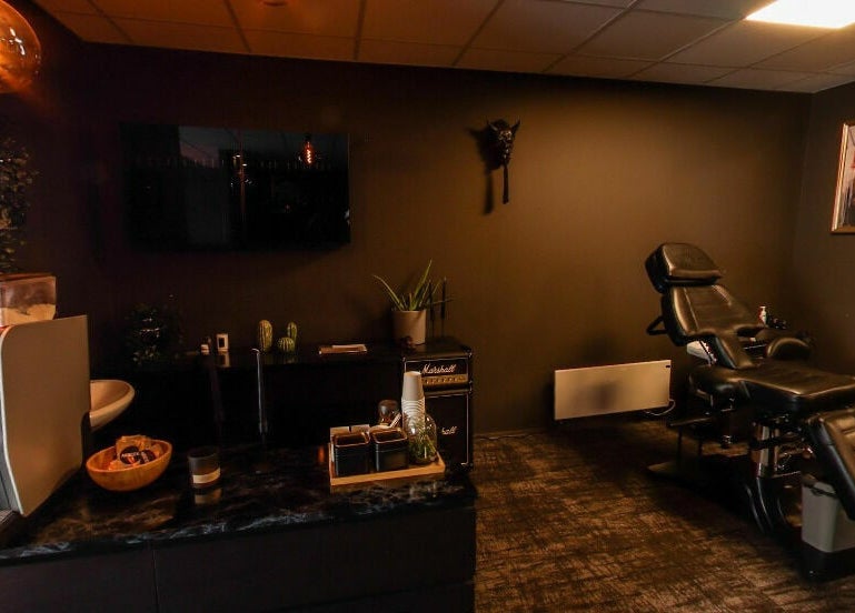 Luxurious massage room at Kristiansand, Agder, NO with comfortable black chair and ambient lighting.