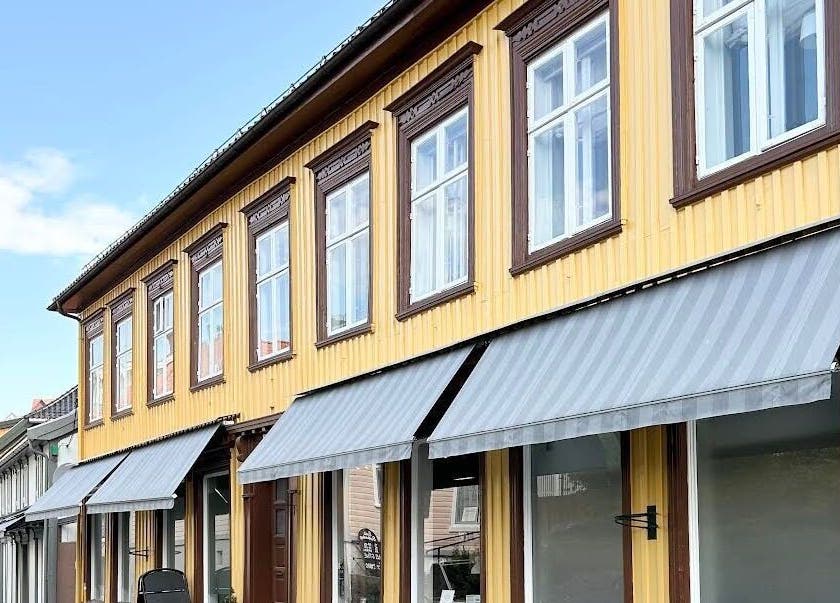C me Beauty, en sjarmerende gul bygning med grå markiser i Brevik, Telemark, NO.