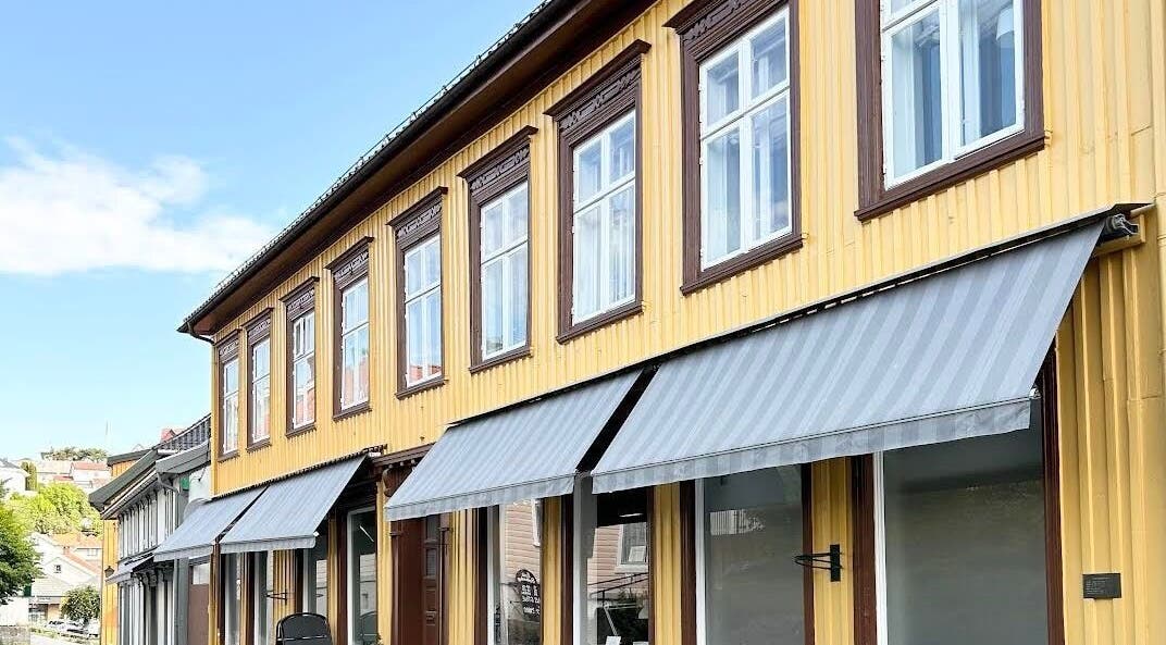C me Beauty, en sjarmerende gul bygning med grå markiser i Brevik, Telemark, NO.