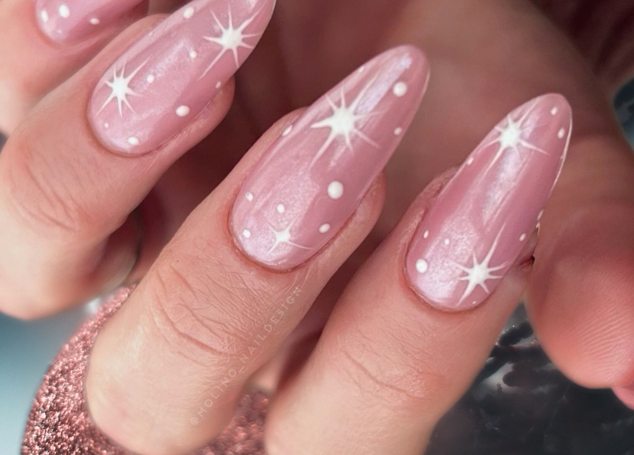 Nærbilde av rosa negler med hvite stjerner hos C me Beauty, Brevik, Telemark, NO.