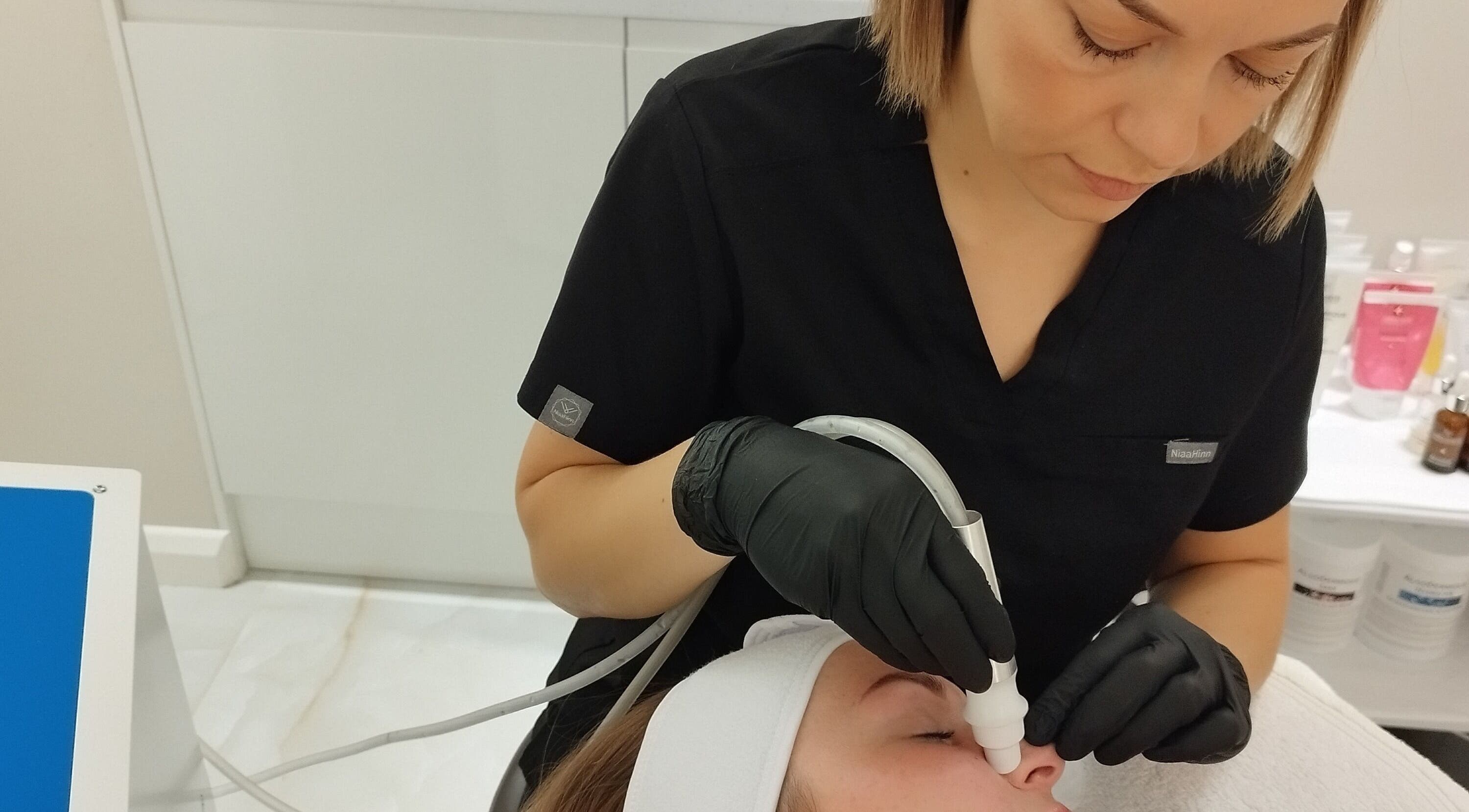 Facial treatment at Amani Beauty Clinic in Pool, England, GB. Aesthetician using advanced equipment.