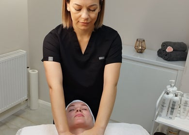 Therapist provides facial massage at Amani Beauty Clinic in Pool, England, GB.