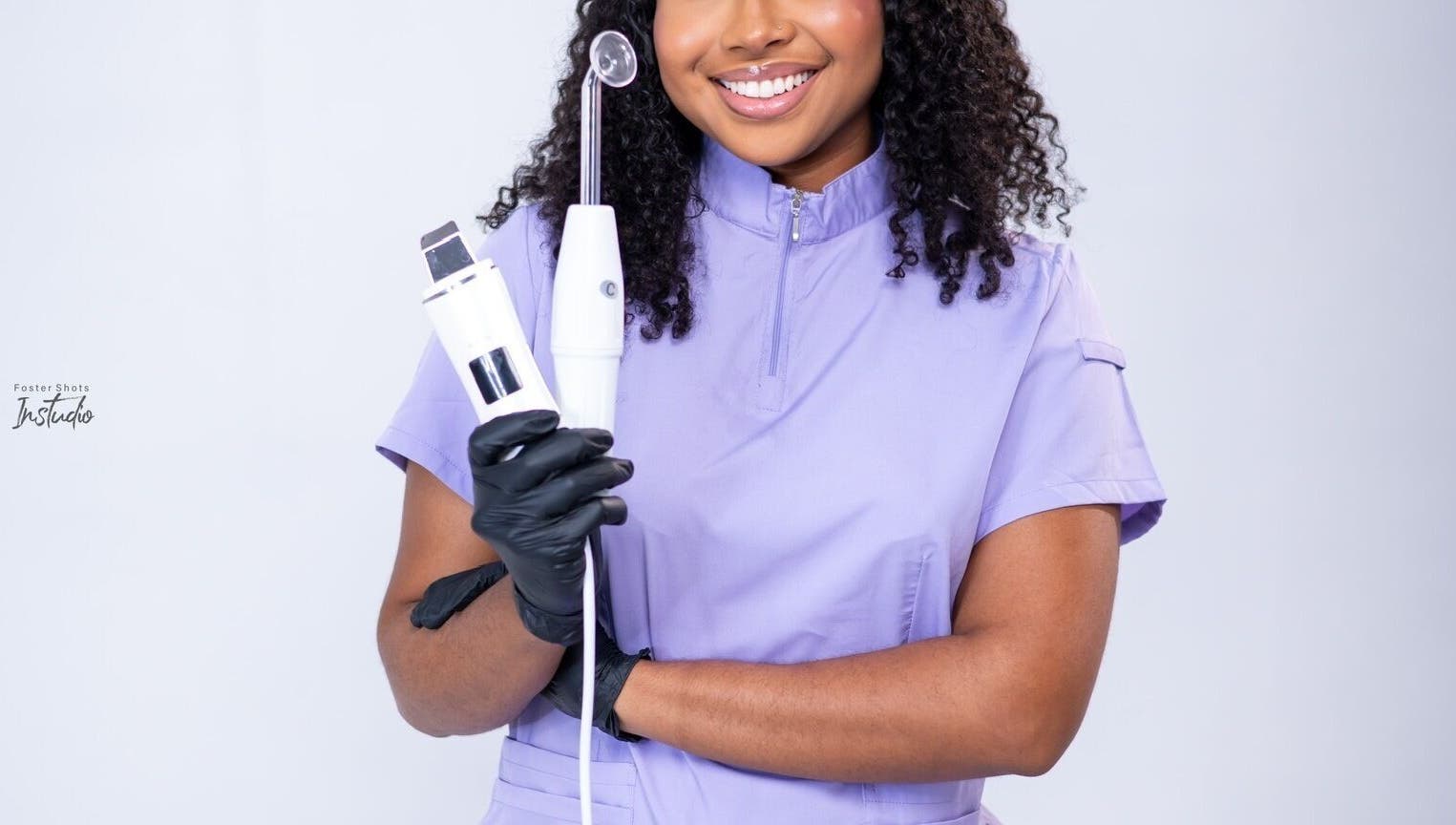 Skincare specialist at Ruellia Aesthetics Kingston, St. Andrew Parish, JM holding beauty tools, smiling confidently.