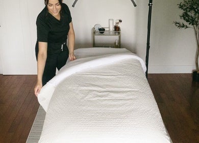 Warm spa room setup at Brittney Finch Esthetics in Ottawa, Ontario, CA, showcasing a serene bed and ambiance.