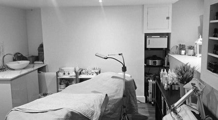 A cozy treatment room at Nova Beauty, Douglas, GB with a massage table and ambient lighting.