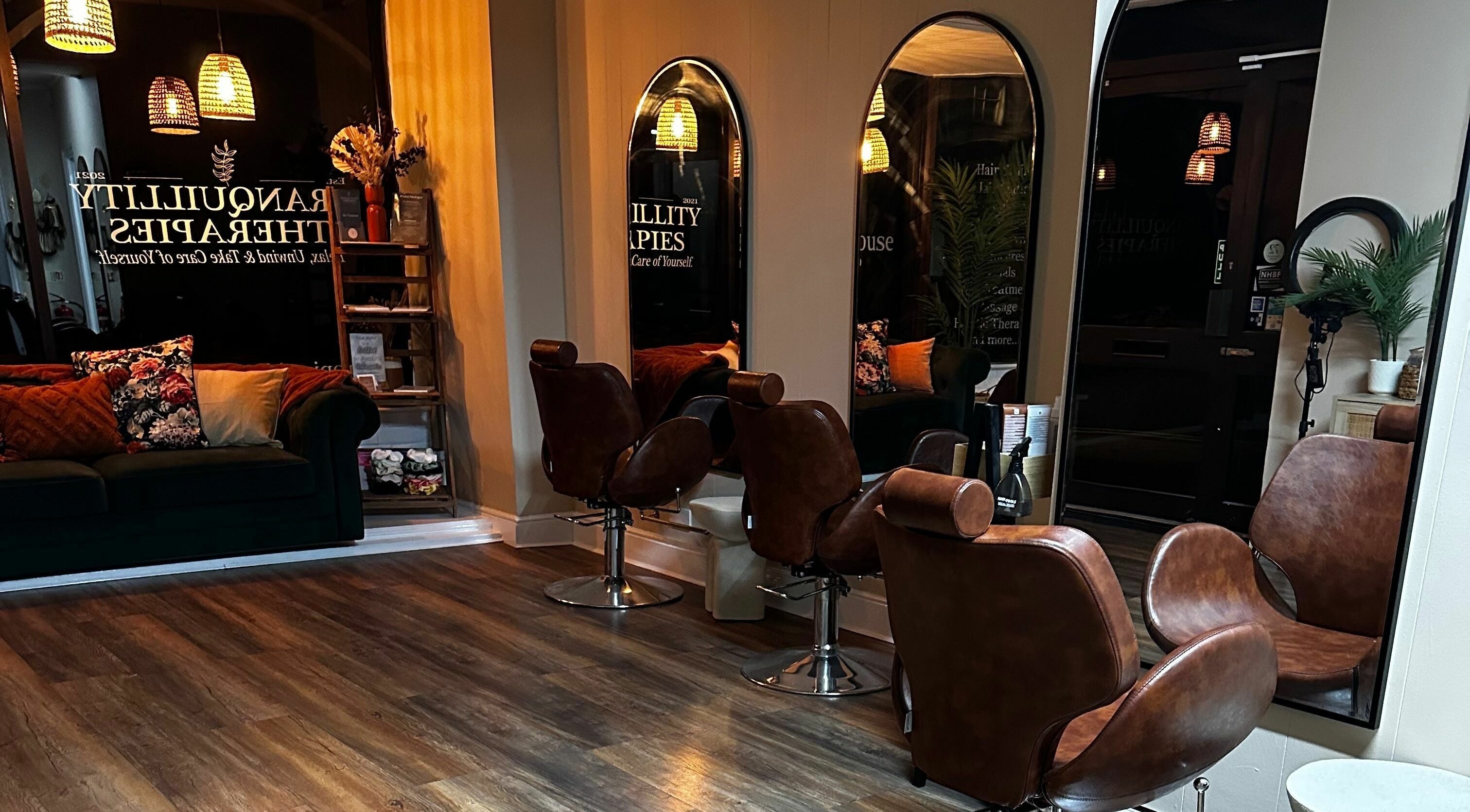 Stylish interior of Khartoum House Hair Studio, Ipswich, England, GB with chic chairs and a cozy sofa.