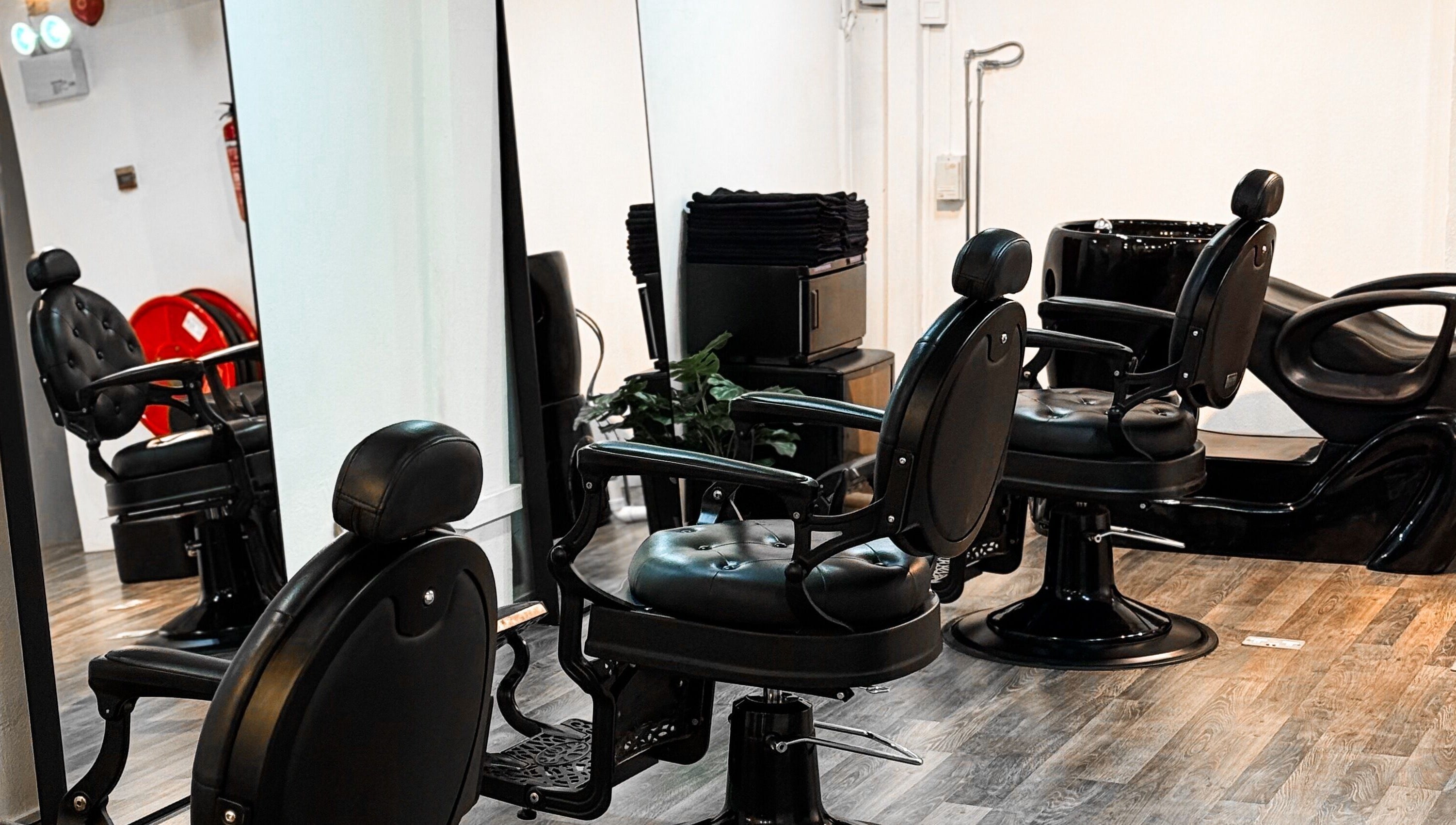 Elegant black salon chairs at Mane Of Man, Singapore, SG, reflecting luxury and comfort.