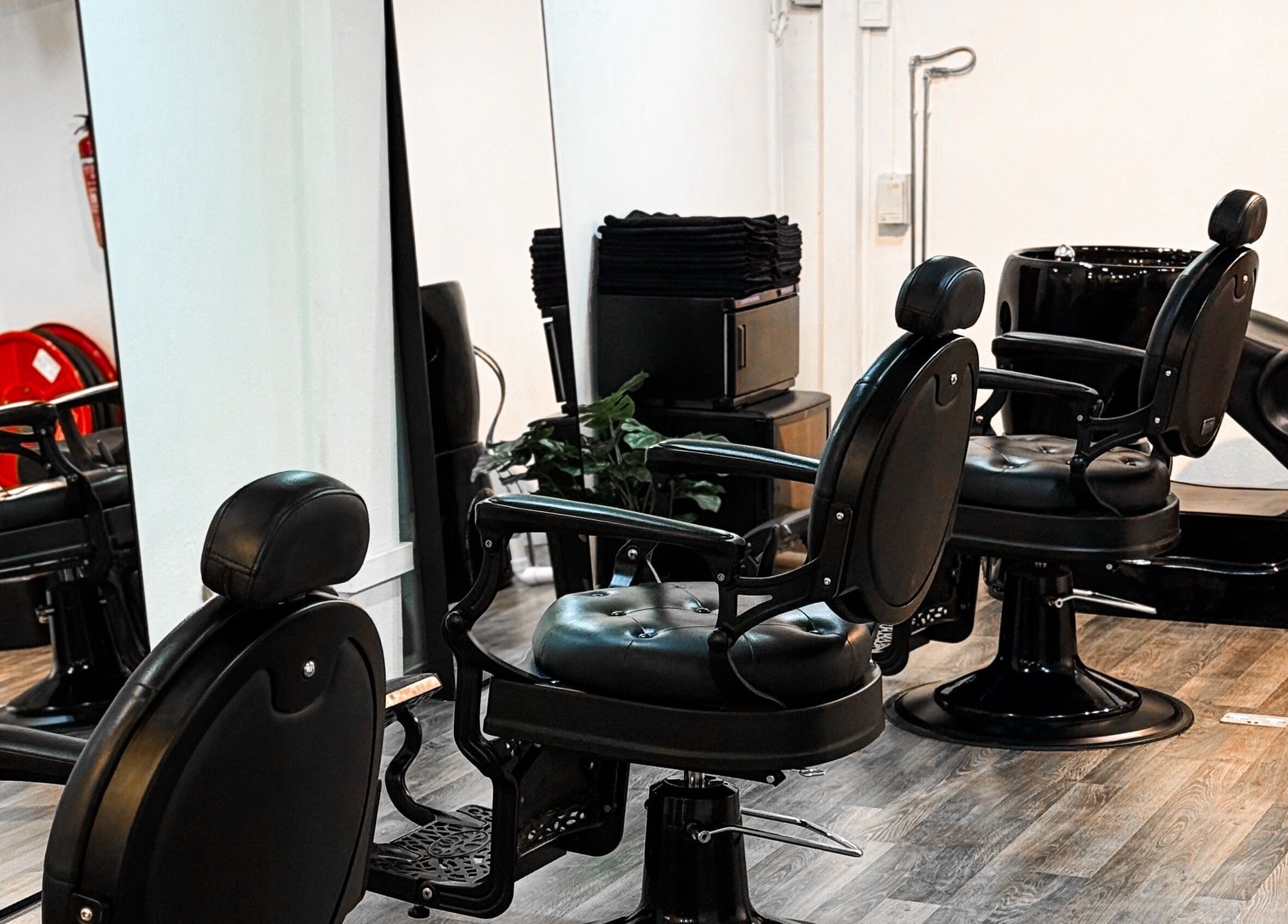 Elegant black salon chairs at Mane Of Man, Singapore, SG, reflecting luxury and comfort.
