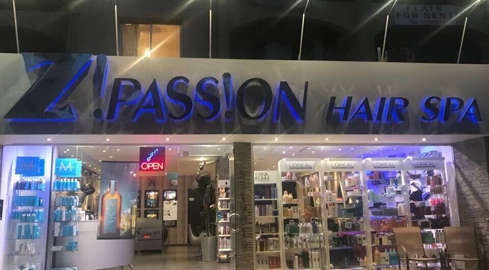 Entrance of Z! Passion Hair Spa in Limassol, CY sparkling at night with beauty products displayed.