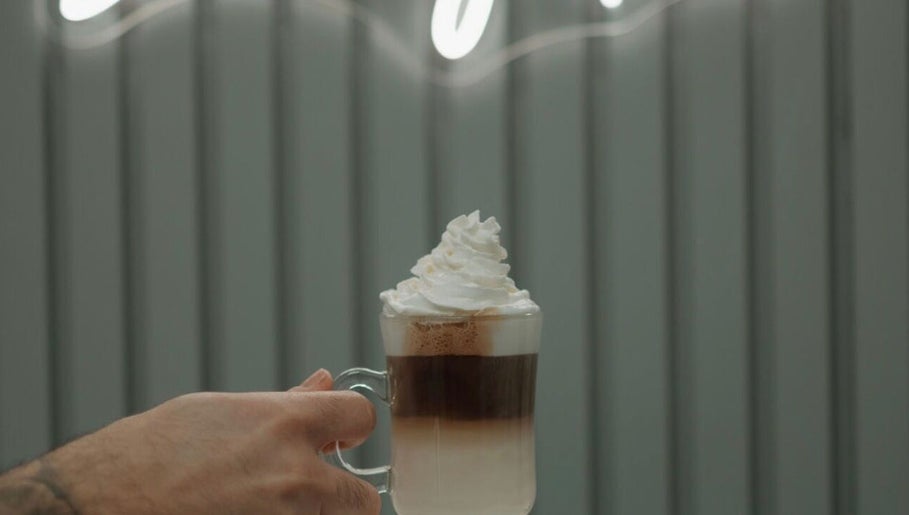 A creamy, layered latte topped with whipped cream at Shine by Bre, Orlando, Florida, US.