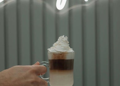A creamy, layered latte topped with whipped cream at Shine by Bre, Orlando, Florida, US.