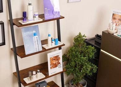 Elegant product display at Saiqs Hair and Beauty, London, England, GB, showcasing skincare items on wooden shelves.