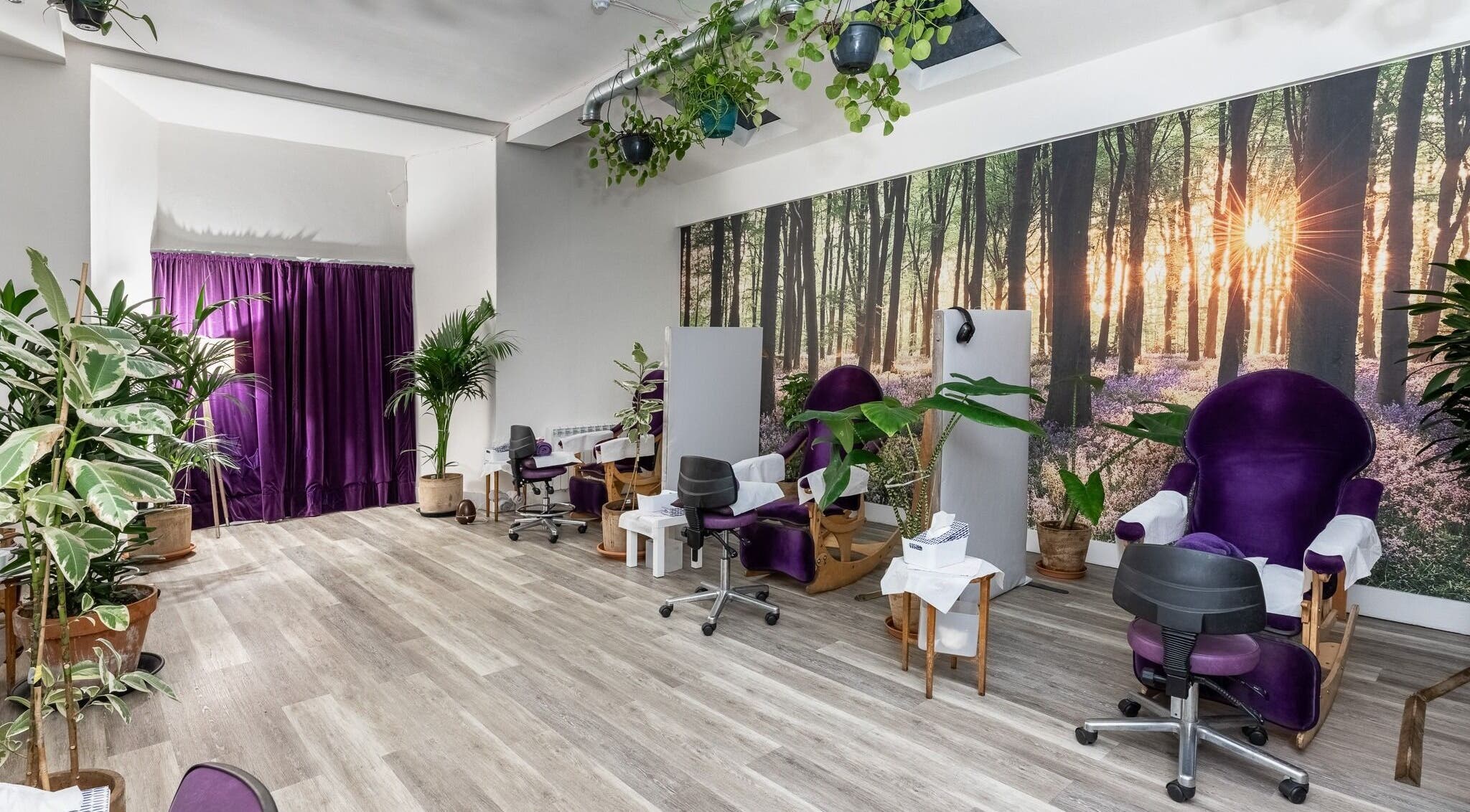 Relaxing treatment room at Reflexions Bayswater, London, England, GB with purple chairs and green plants.