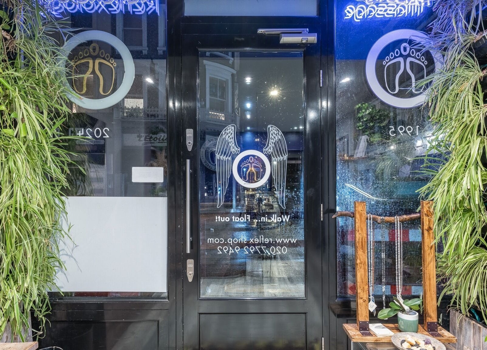 Entrance of Reflexions Bayswater in London, England, GB, with lush greenery and welcoming decor.