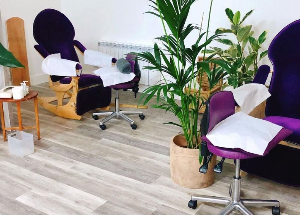 Relaxing treatment chairs at Reflexions Clapham, London, England, GB, surrounded by lush plants.