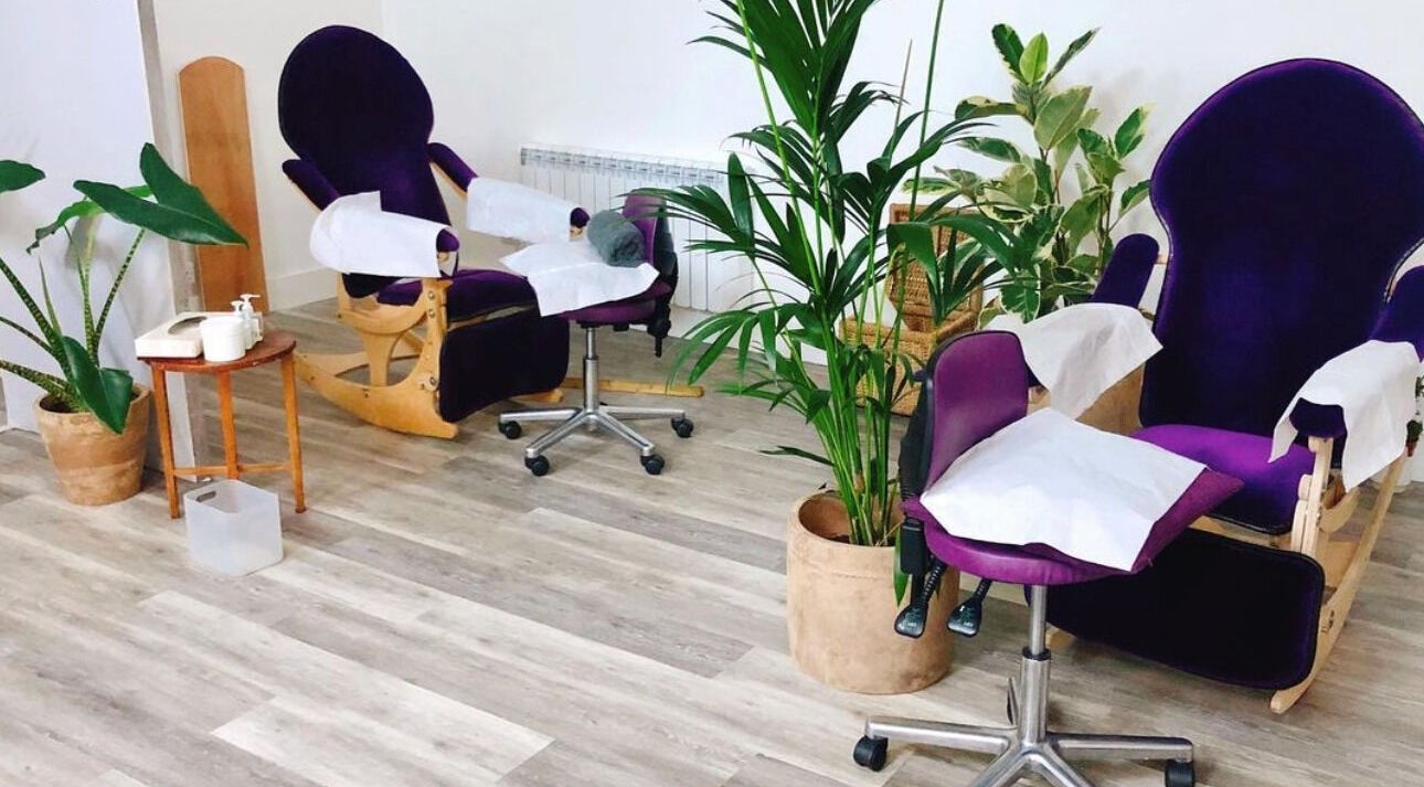 Relaxing treatment chairs at Reflexions Clapham, London, England, GB, surrounded by lush plants.