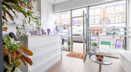 Inviting interior of Reflexions Clapham with lush plants and bright decor, located in London, England, GB.