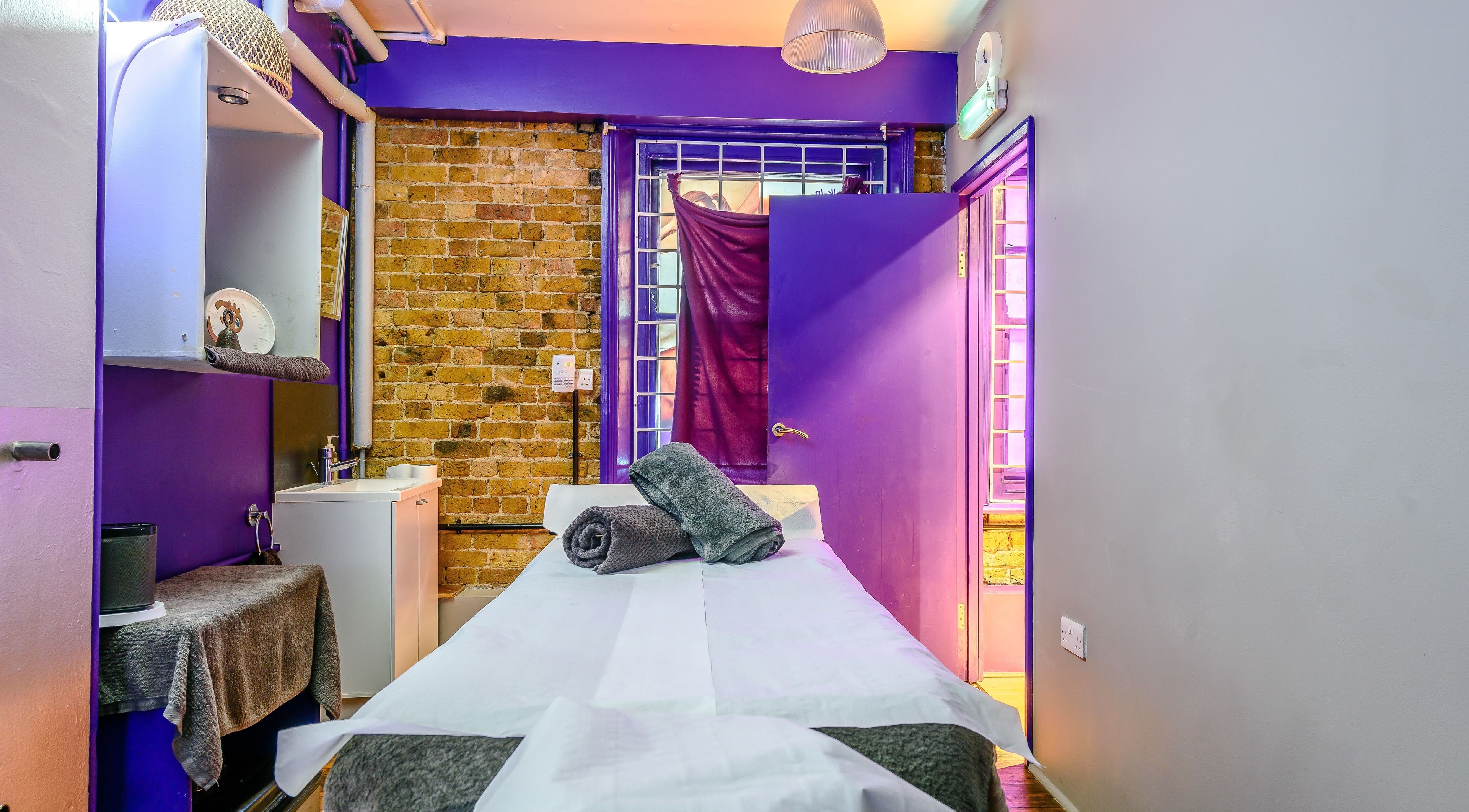 Cozy therapy room with purple accents at Reflexions Chelsea, London, England, GB, ideal for relaxation.