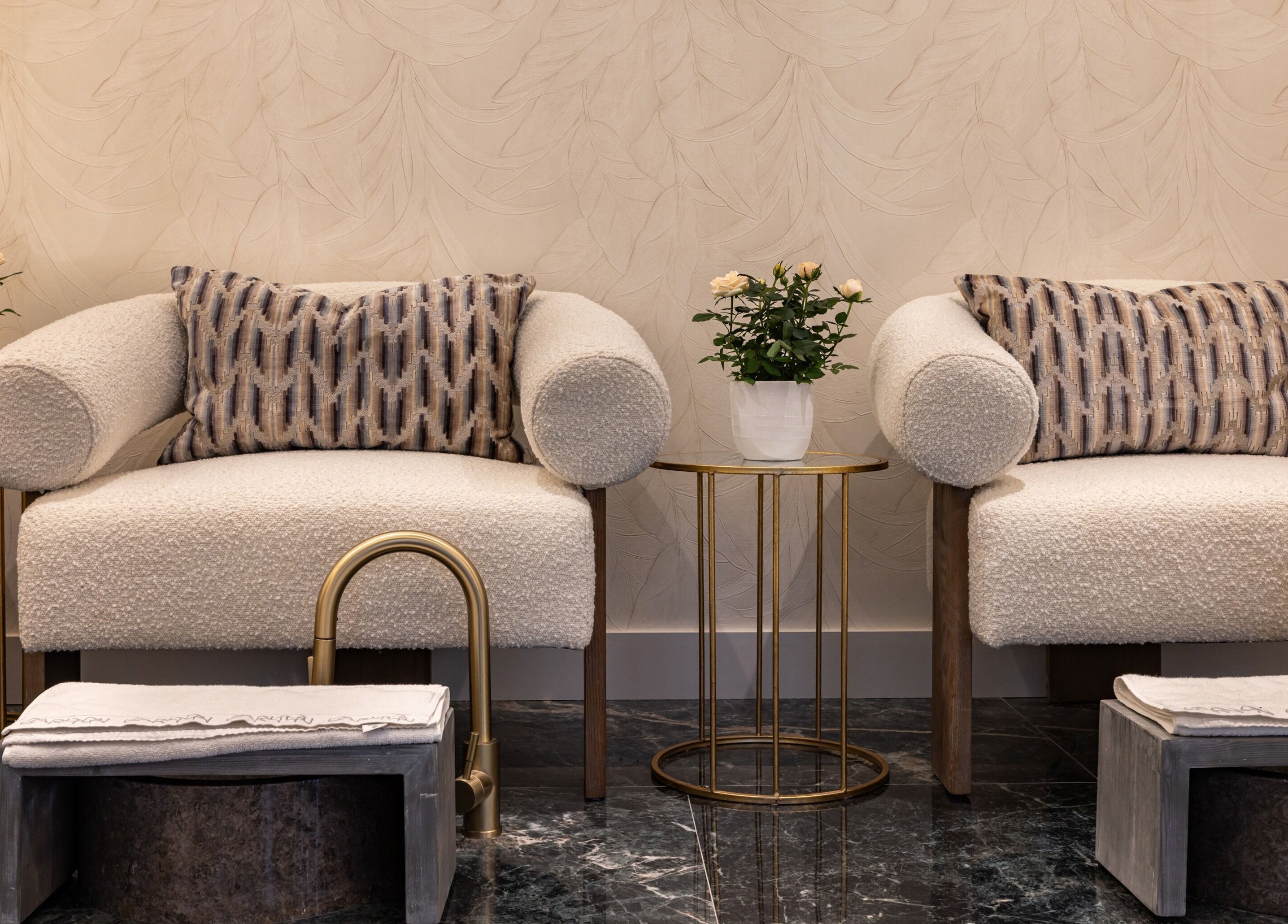 Elegant lounge area at The Hamptons Nails & Beauty, London, England, GB, with plush seating and chic decor.