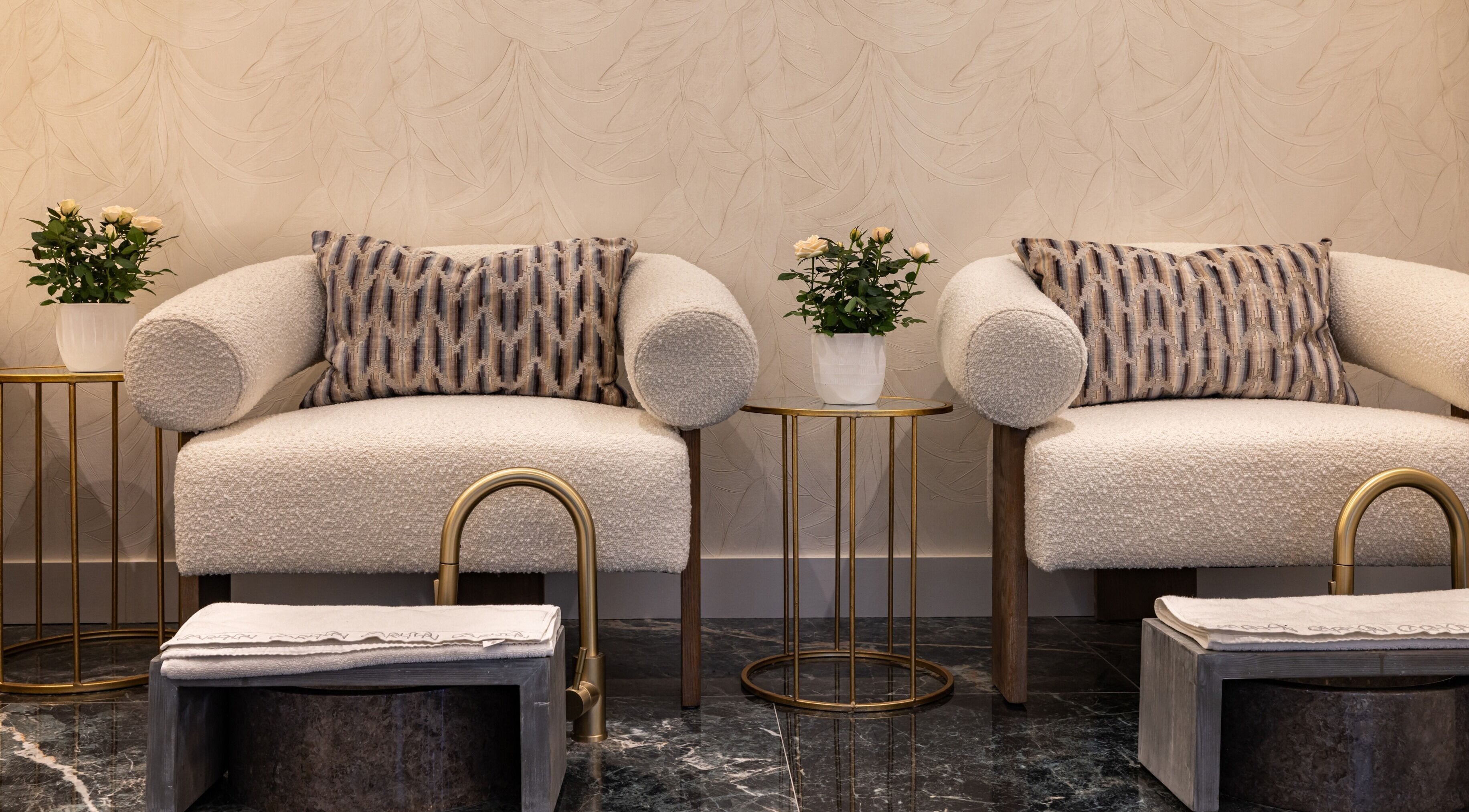 Elegant lounge area at The Hamptons Nails & Beauty, London, England, GB, with plush seating and chic decor.