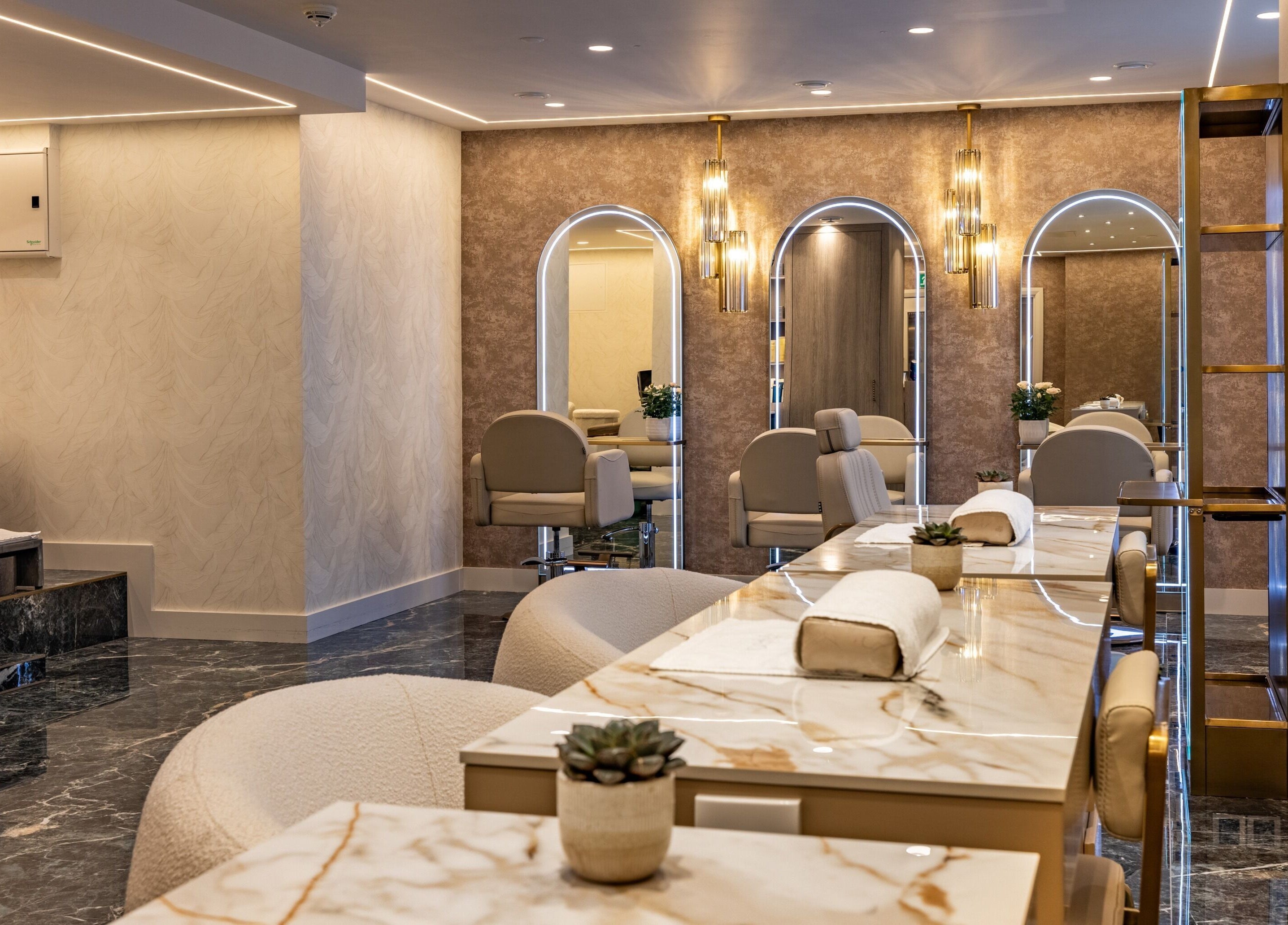 Luxurious interior of The Hamptons Nails & Beauty in London, England, GB, showcasing elegant nail stations.