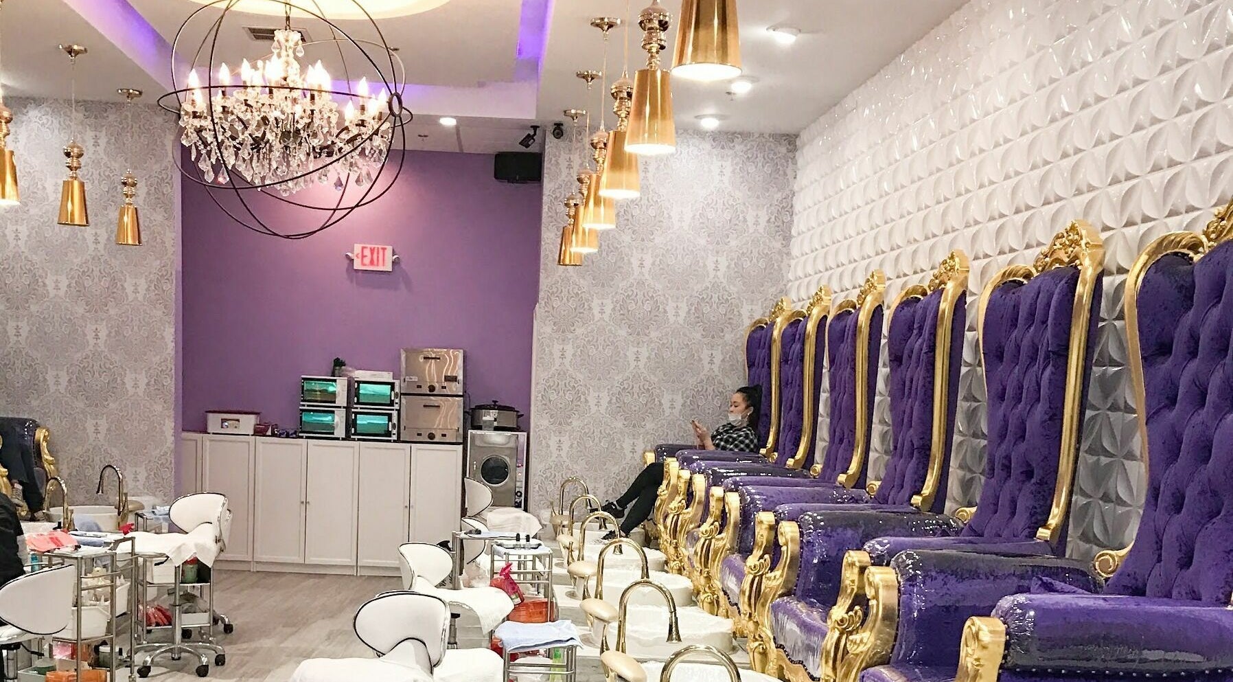 Luxurious nail treatment area at The Nail Place in Evergreen Park, Illinois, US with purple velvet chairs.