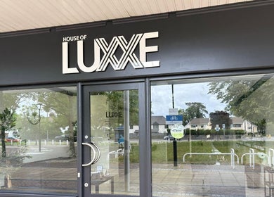 Front entrance of House of Luxxe Beauty Salon in Yate, England, GB with sleek signage.