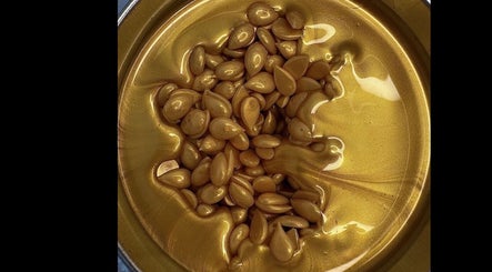 Gold-toned beauty serum from Fresca Beauty, Toronto, Ontario, CA in a glossy, inviting texture.