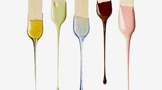 Vibrant wax colors dripping from sticks at W.E. WAX, Arima, Arima Borough Corporation, TT.