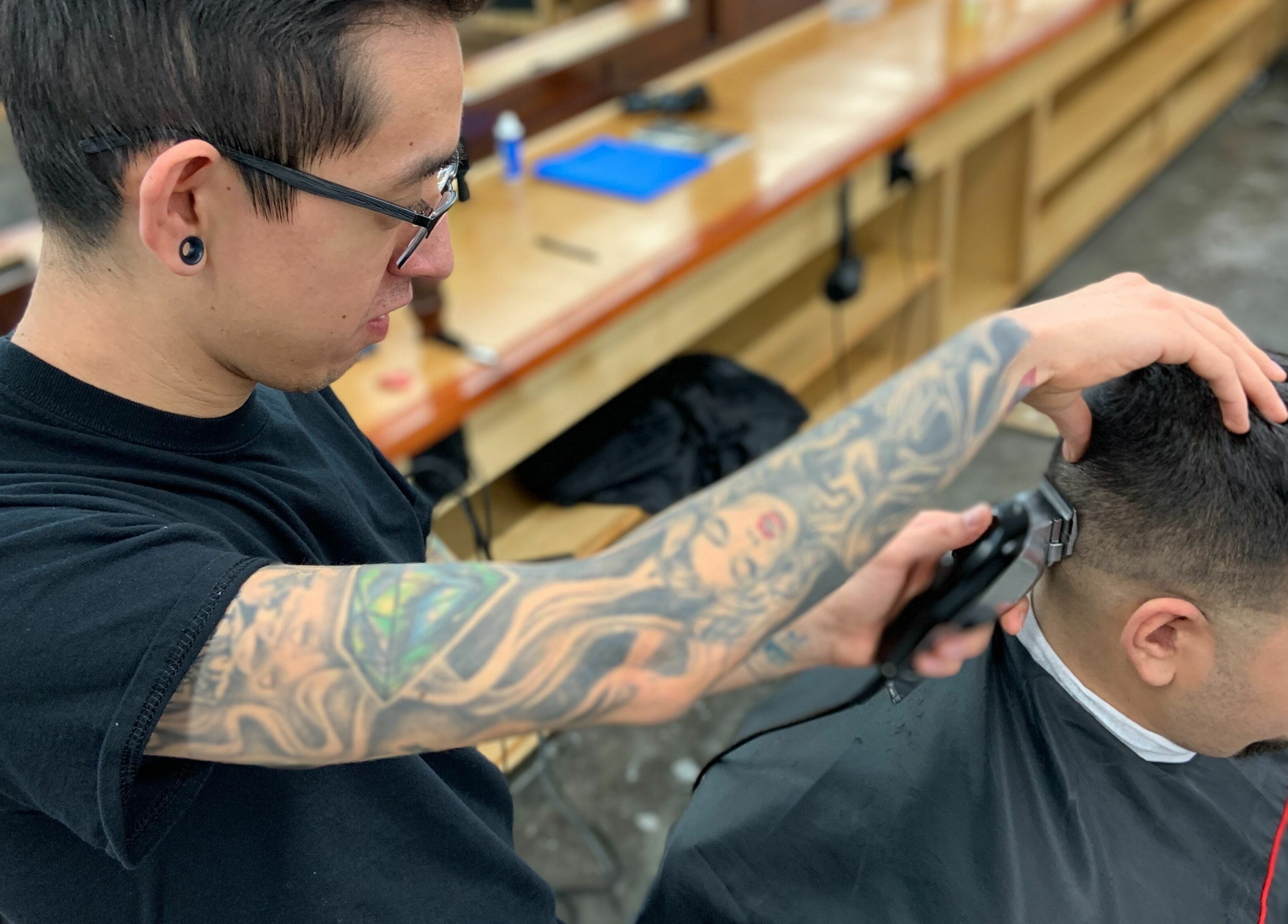 A barber skillfully cutting hair at Tonsore Master Academy in San Antonio, Texas, US.