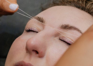 Eyebrow threading at Sophia Georgiou Salon, Stockport, England, GB. Close-up of expert hand threading technique.