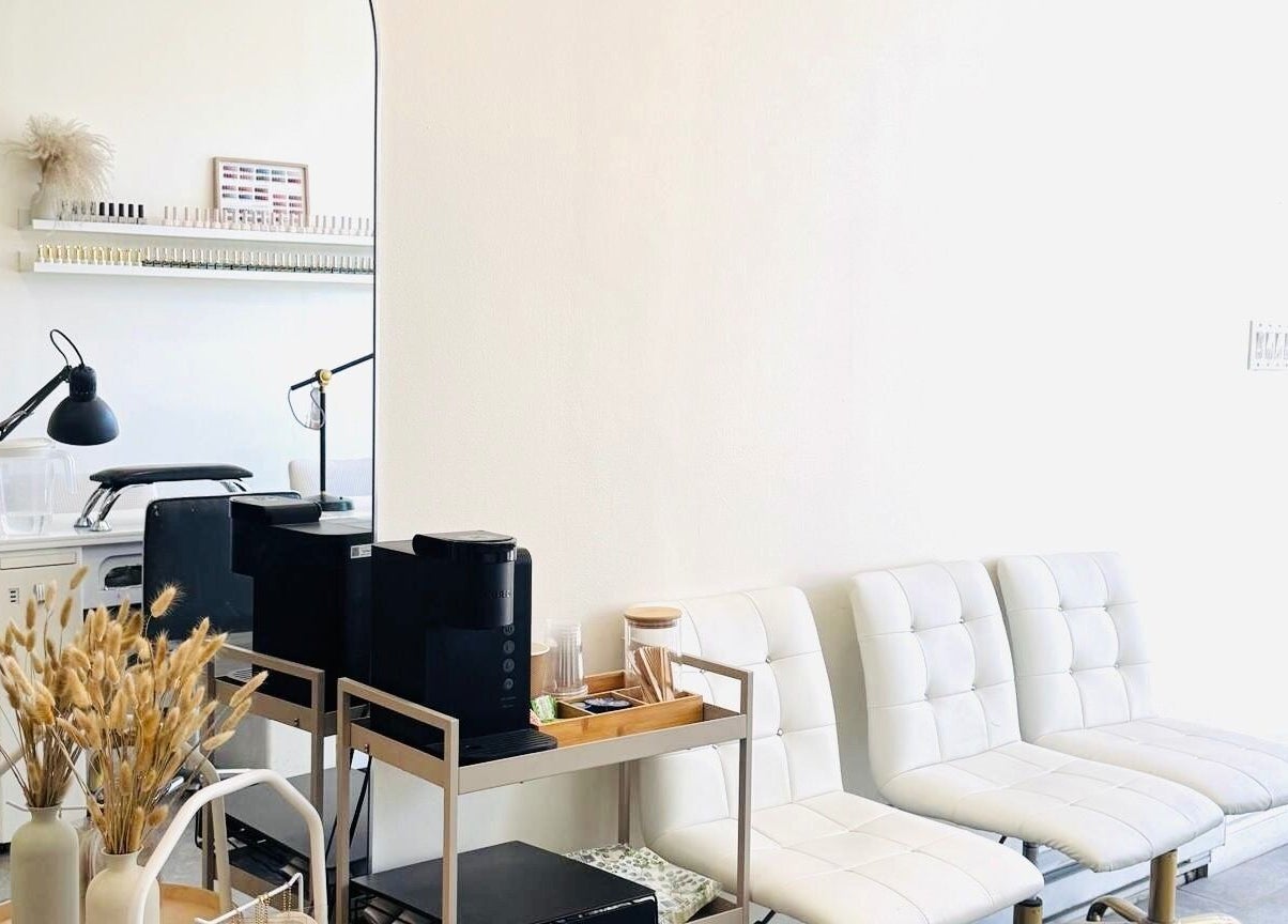 Modern seating area at Sarang Nails in Toronto, Ontario, CA, featuring stylish white chairs and decor.