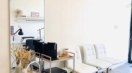 Modern seating area at Sarang Nails in Toronto, Ontario, CA, featuring stylish white chairs and decor.