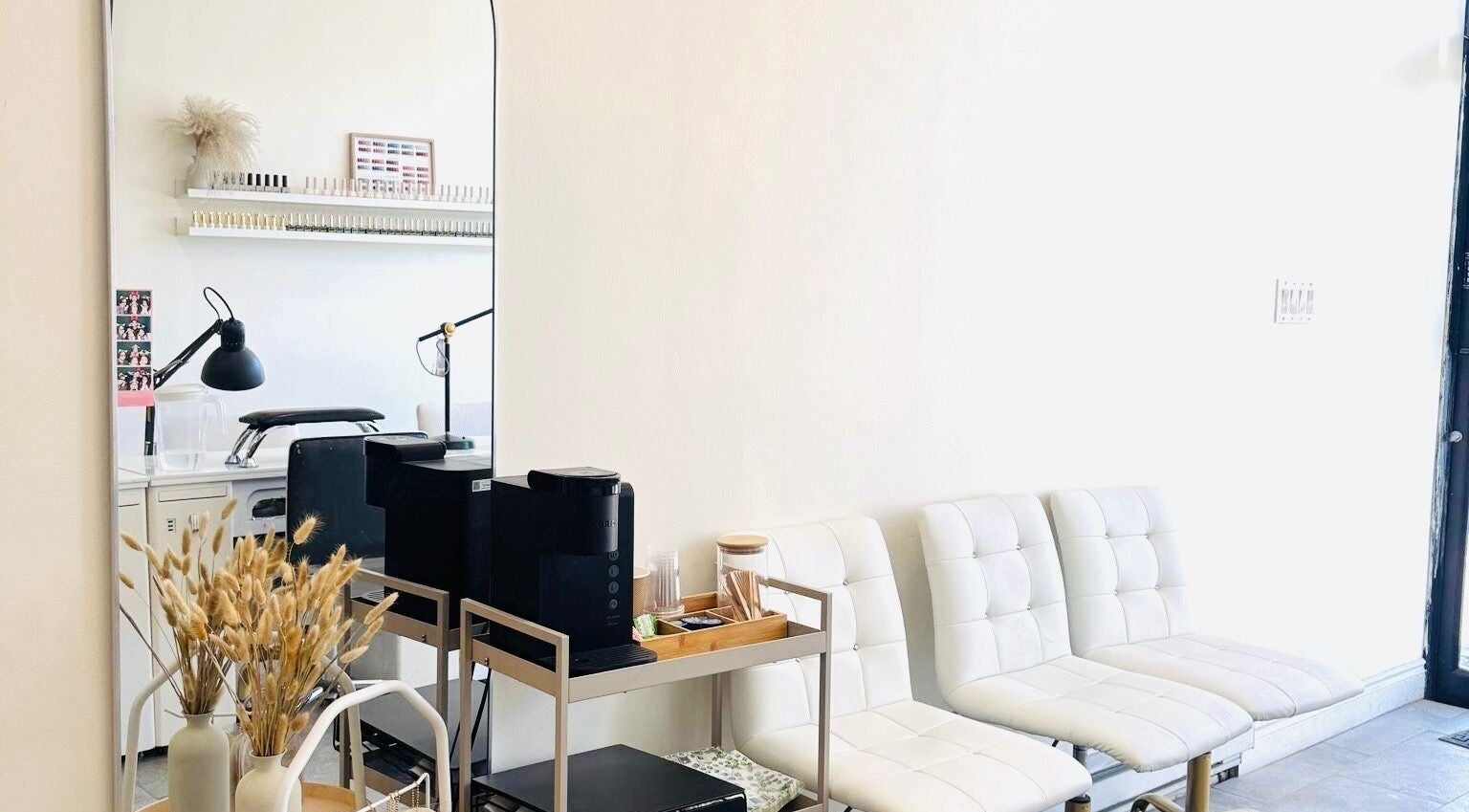 Modern seating area at Sarang Nails in Toronto, Ontario, CA, featuring stylish white chairs and decor.