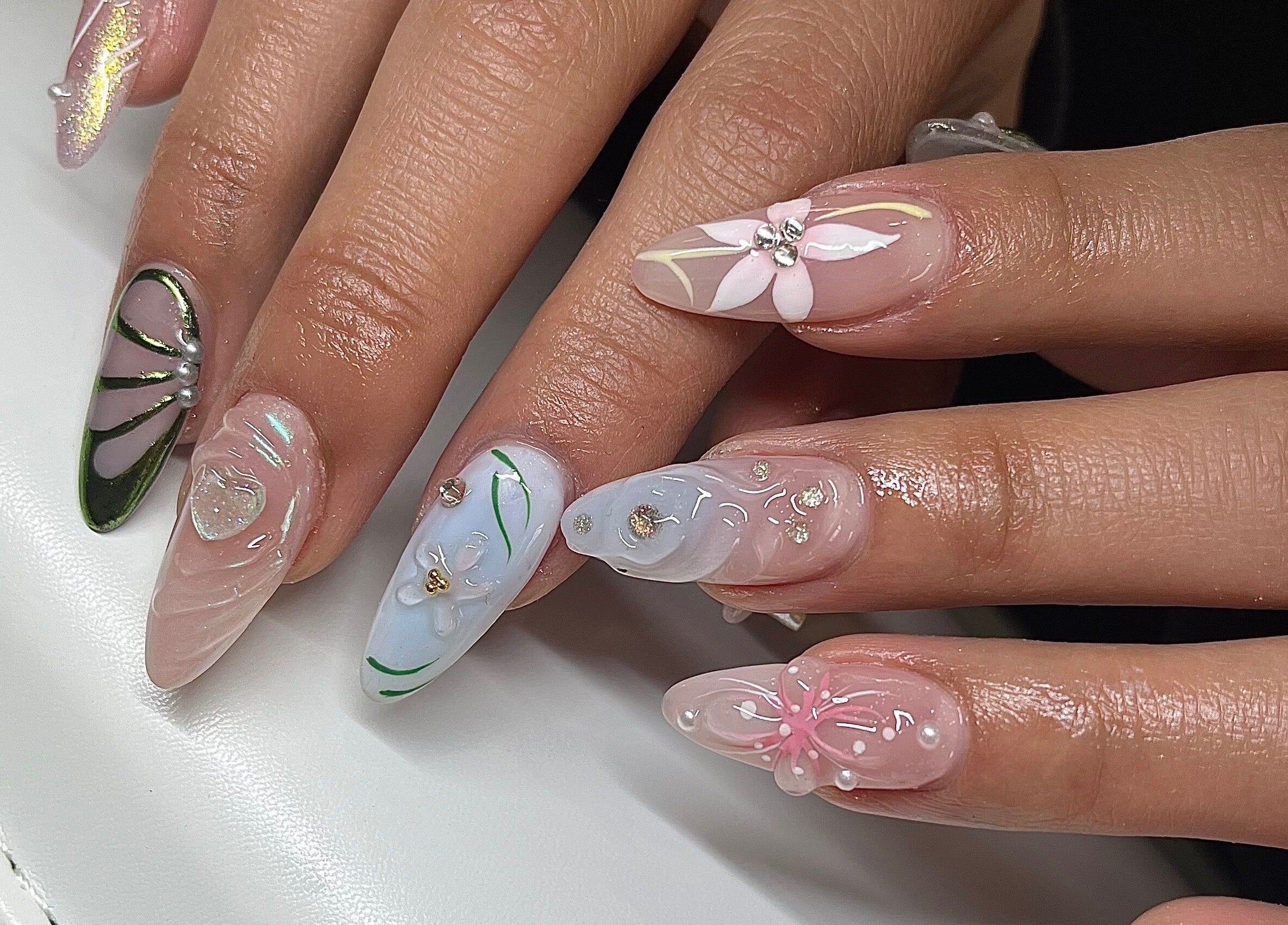 Elegant floral nail art by Sarang Nails in Toronto, Ontario, CA, showcasing intricate designs and gems.