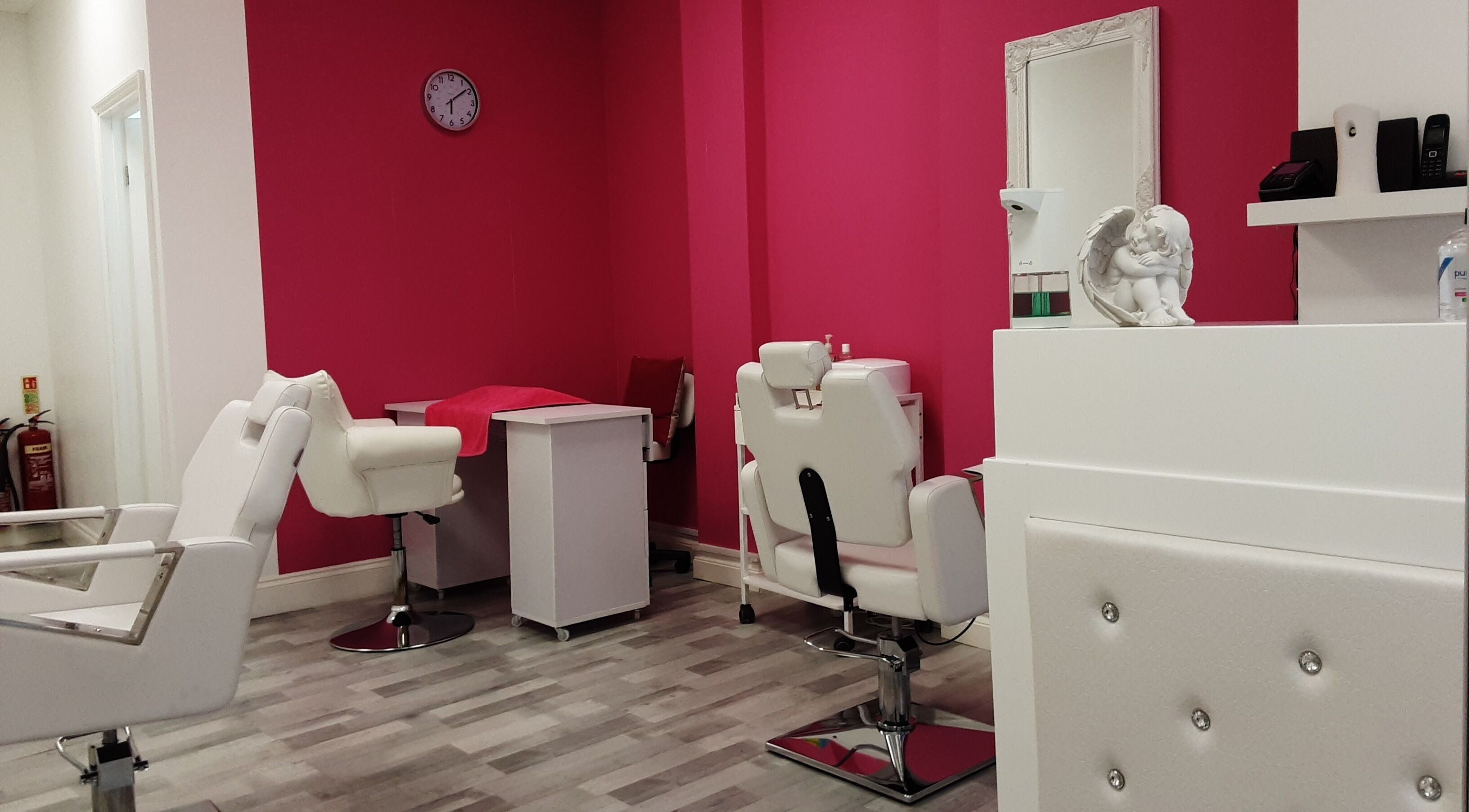 Modern interior of Anangels Beauty Shop in London, England, GB with stylish white chairs and vibrant pink walls.