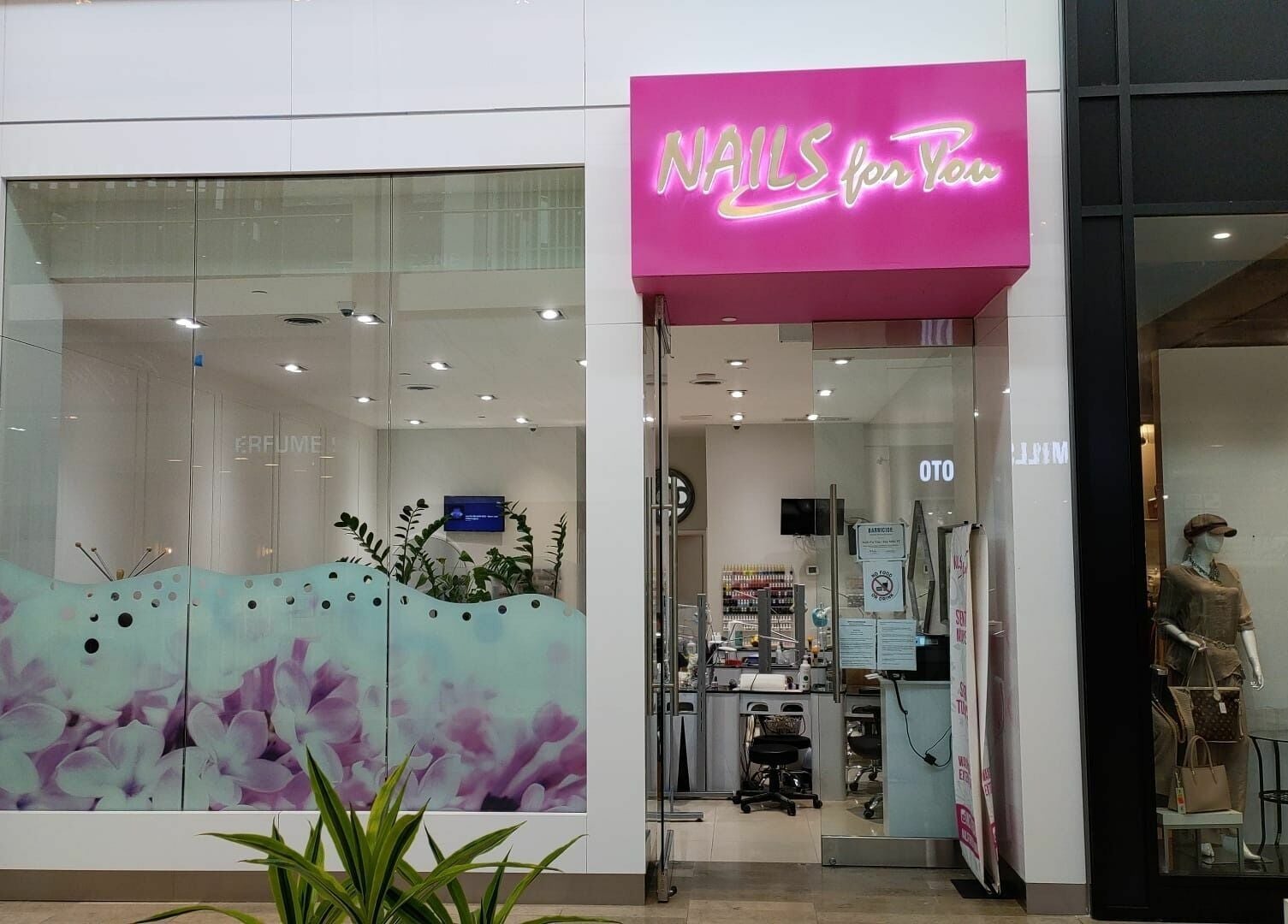 Front view of Nails For You Erin Mills in Mississauga, Ontario, CA featuring vibrant signage and floral decor.