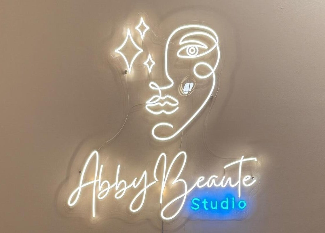 Neon face outline with Abby Beaute Studio, Cyberjaya, Selangor, MY, glowing sign.