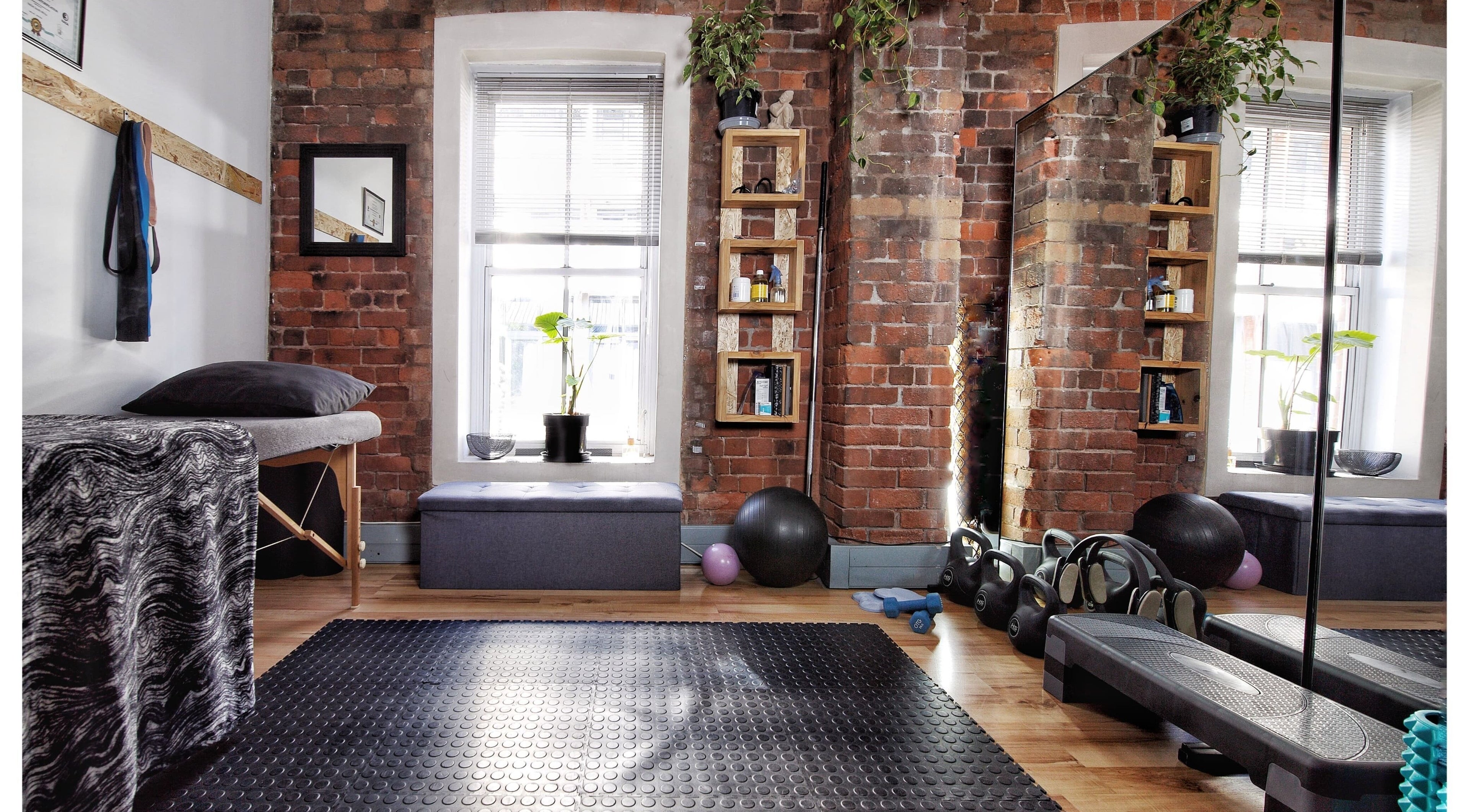 Dynamic Therapy wellness room with fitness tools in Cape Town, Western Cape, ZA, showcasing rustic brick decor.
