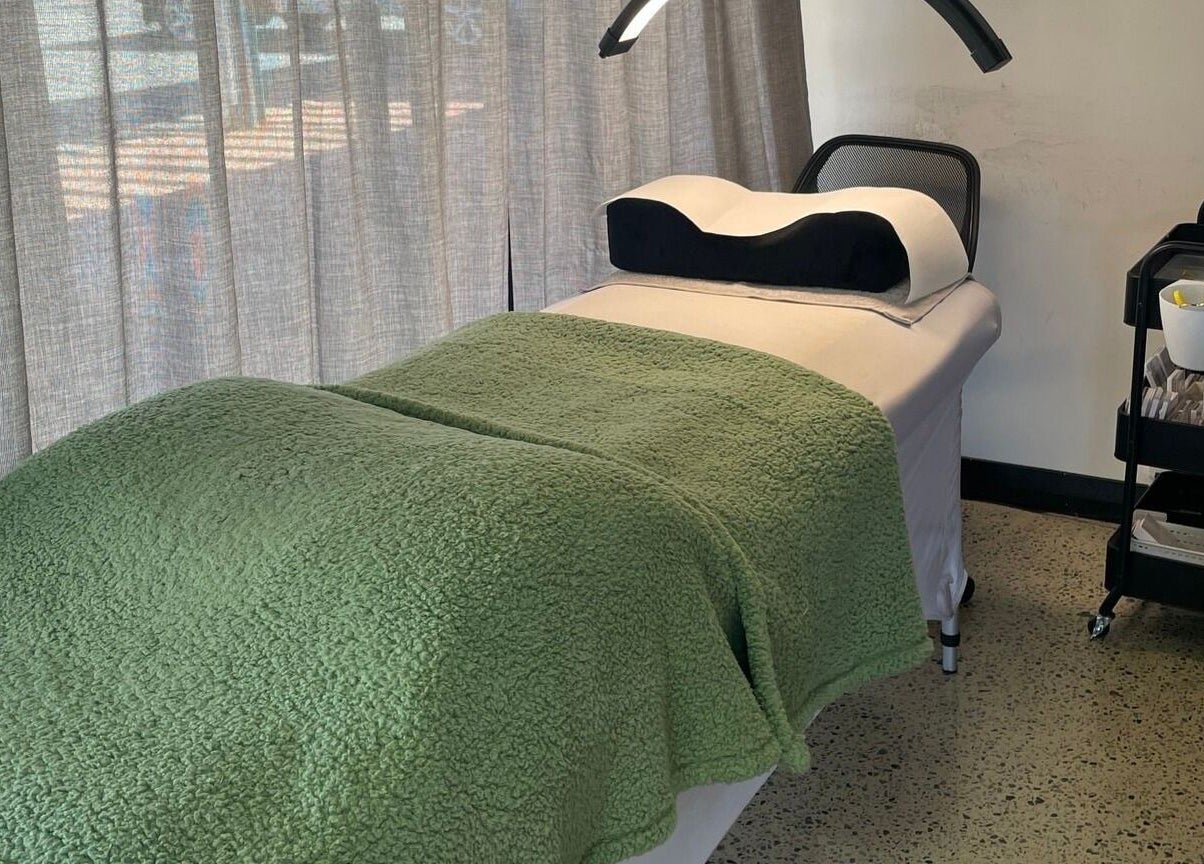 Relaxing treatment bed at All-Eyes Beauty, located in Falcon, Western Australia, AU, with a green cover.