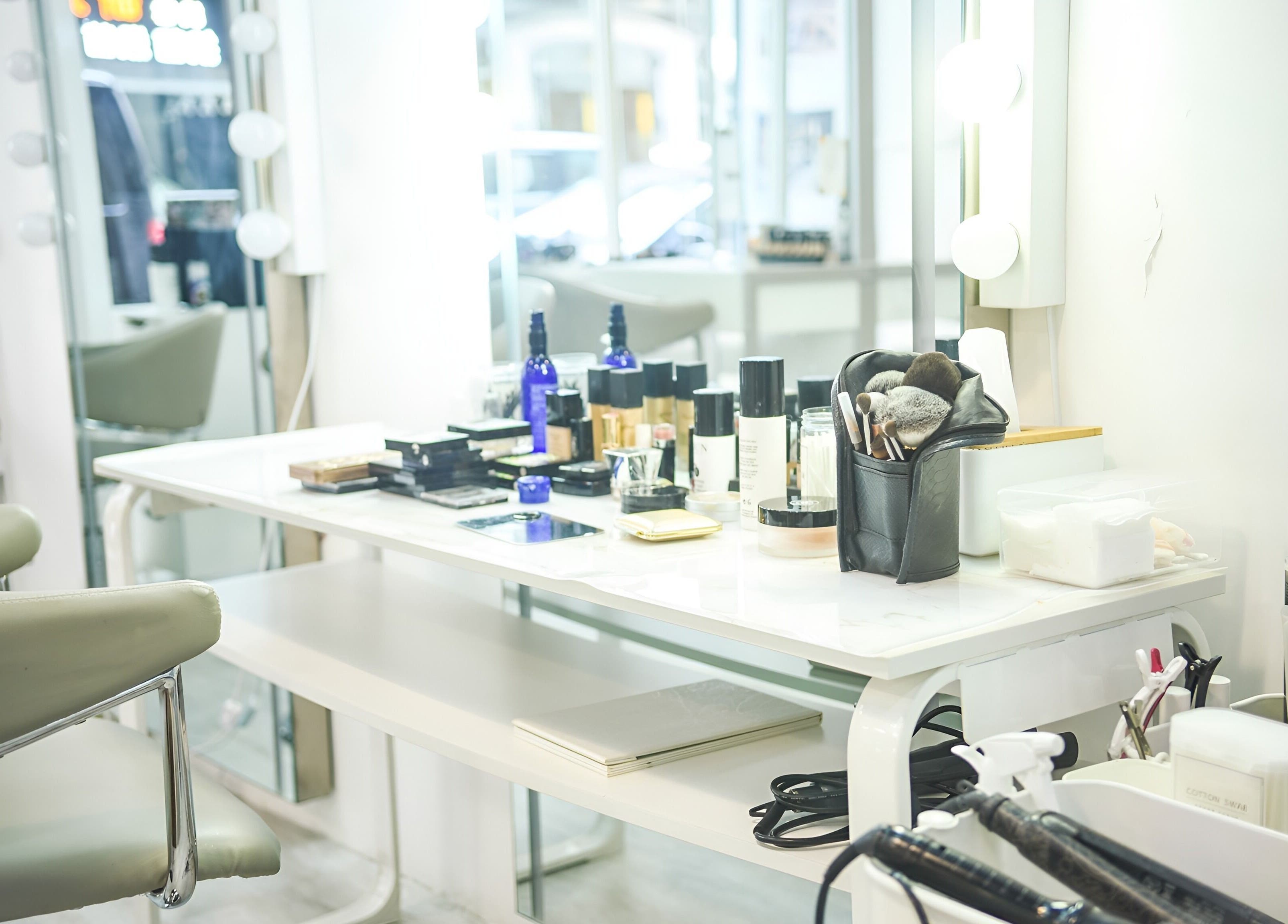 Elegant makeup station at Happy Face Photo Synthesis, Kowloon, HK, with beauty products and mirrors.