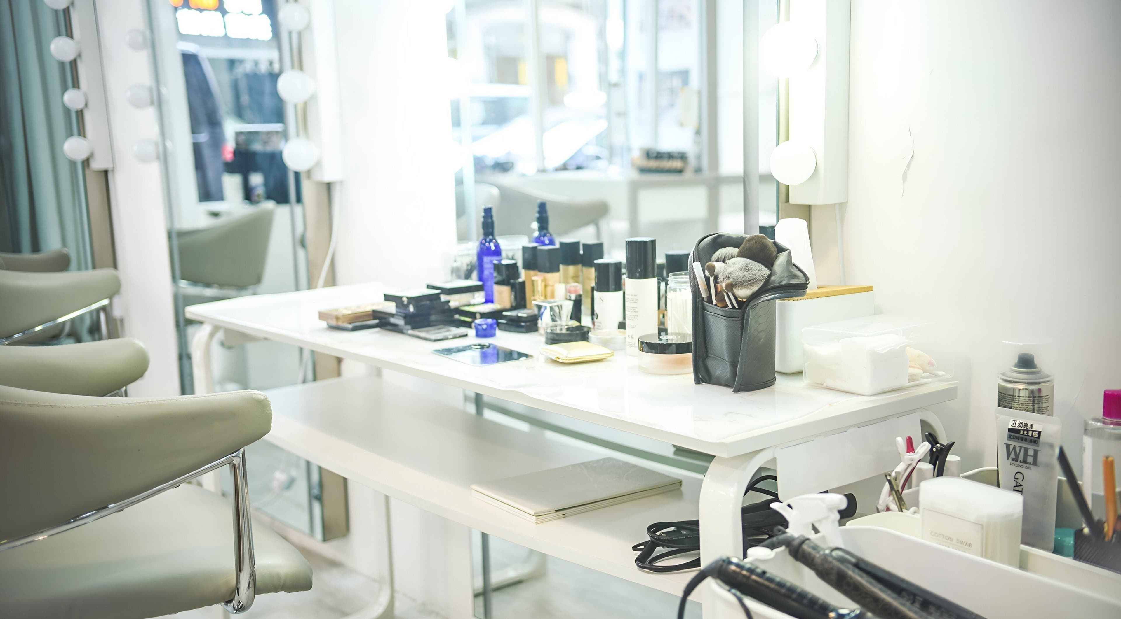 Elegant makeup station at Happy Face Photo Synthesis, Kowloon, HK, with beauty products and mirrors.