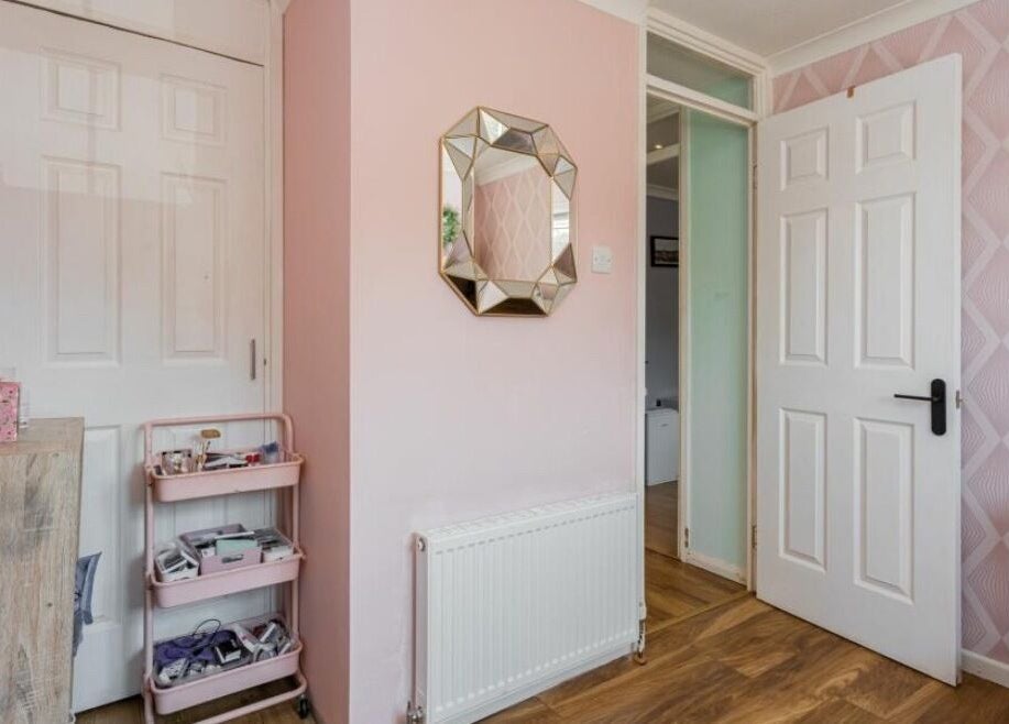 Stylish pink room at Ellie’s Lash Extensions, Copthorne, England, with mirror and decor.