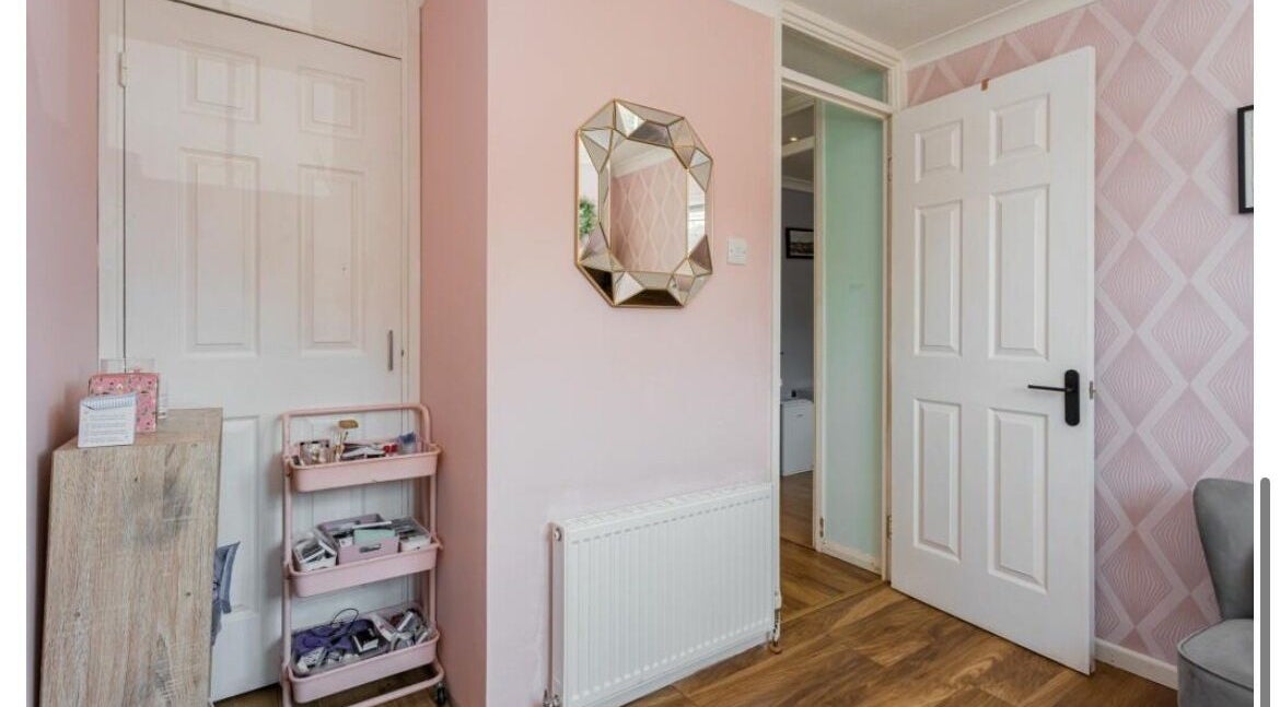 Stylish pink room at Ellie’s Lash Extensions, Copthorne, England, with mirror and decor.